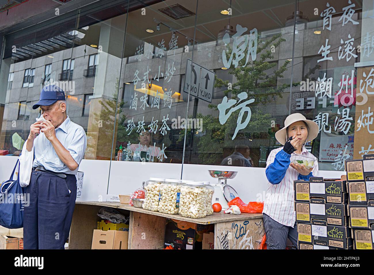 Une scène de rue dans Chinatown, Flushing où deux étrangers ont leur déjeuner. À Queens, New York. Banque D'Images