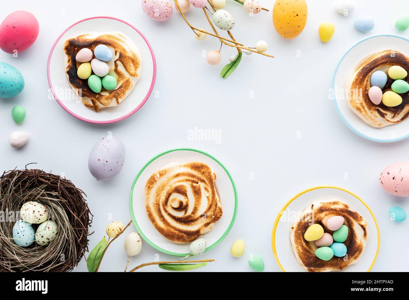 Nids de meringue faits maison remplis de mini œufs de chocolat pour Pâques. Banque D'Images