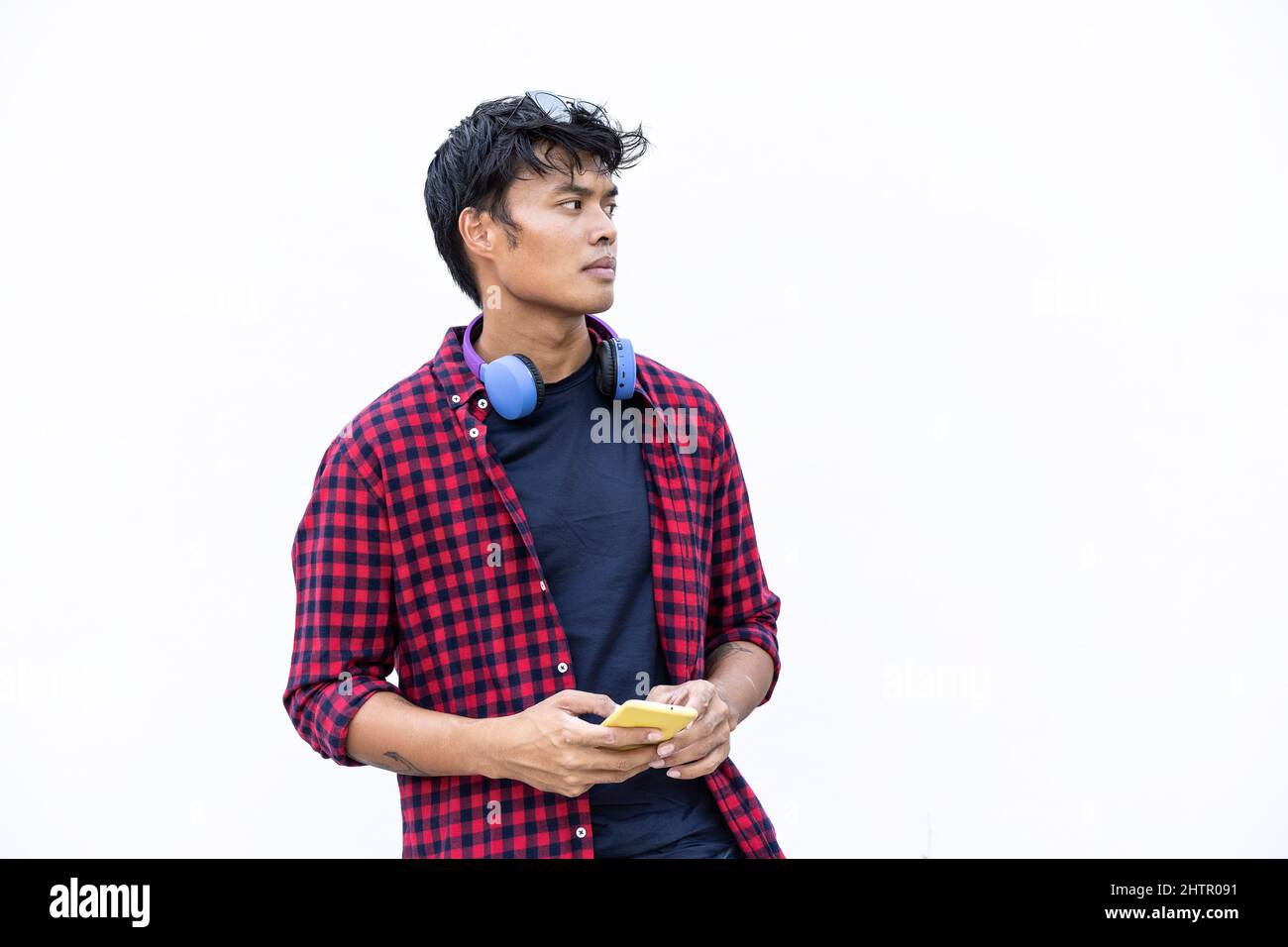 Jeune homme asiatique isolé utilisant un smartphone mobile sur fond blanc - les personnes de génération z et du millénaire sont toujours connectées Banque D'Images