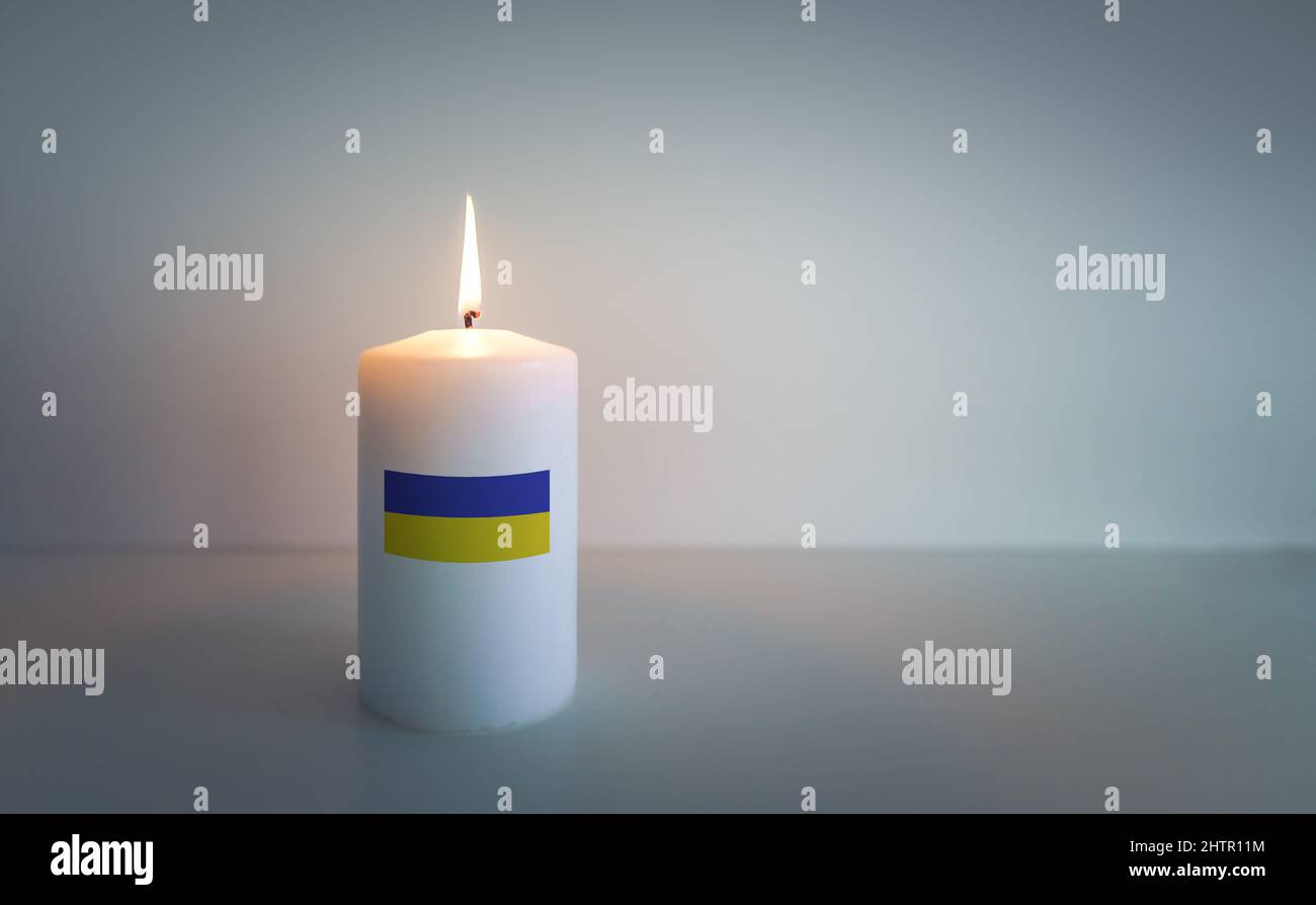 Une bougie avec le drapeau ukrainien comme étiquette brûle pour la paix et  l'espoir Photo Stock - Alamy