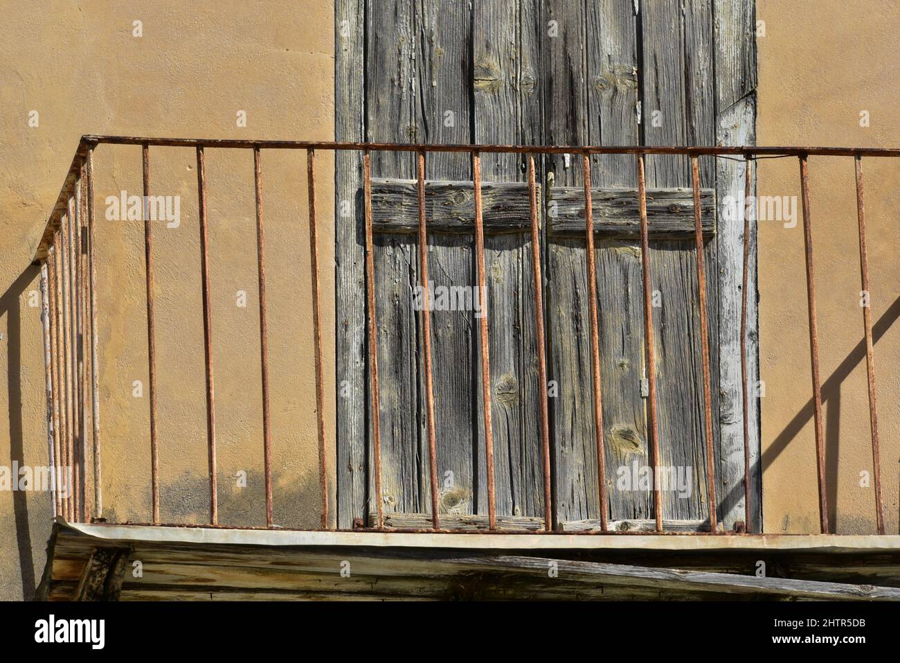 Ancienne maison néoclassique rouillée sur mesure balcon en fer forgé balustrade contre un mur en stuc ocre à Nafplio, Grèce. Banque D'Images