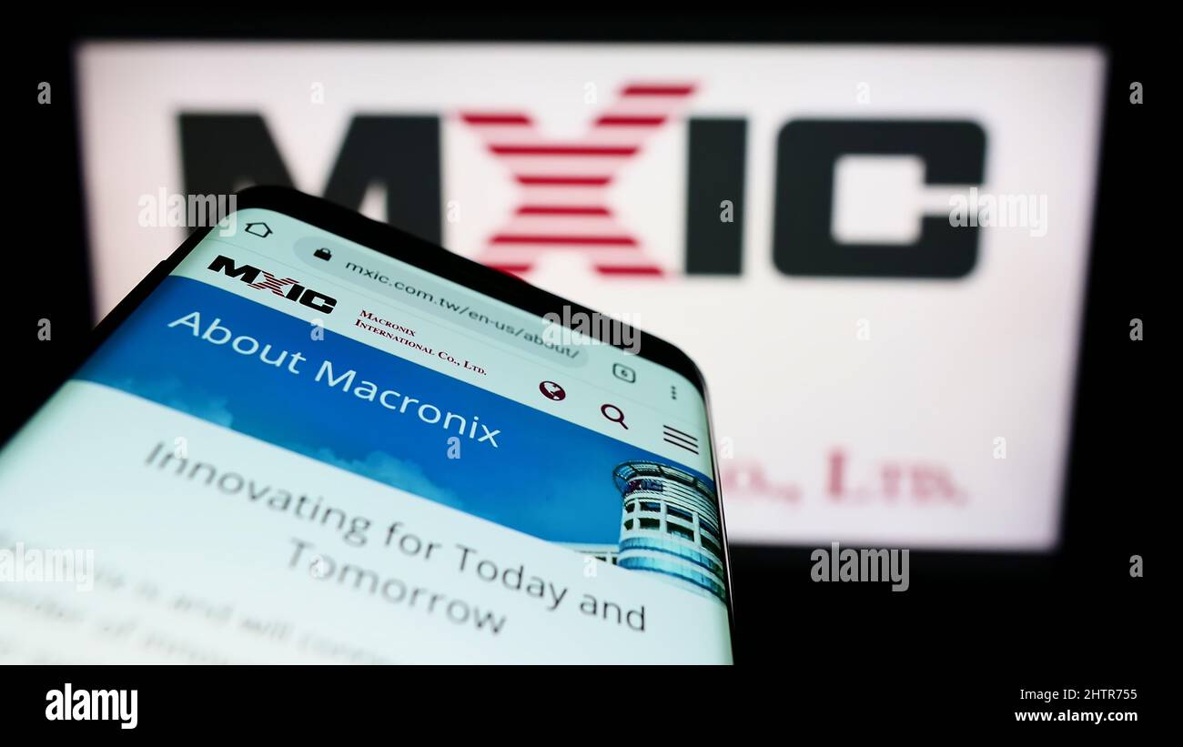 Smartphone avec le site Web de la société taïwanaise Macronix International Co. Ltd. À l'écran devant le logo. Faites la mise au point dans le coin supérieur gauche de l'écran du téléphone. Banque D'Images