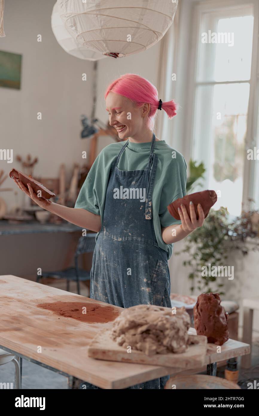 Femme céramiste travaillant avec de l'argile brute dans un studio de poterie Banque D'Images