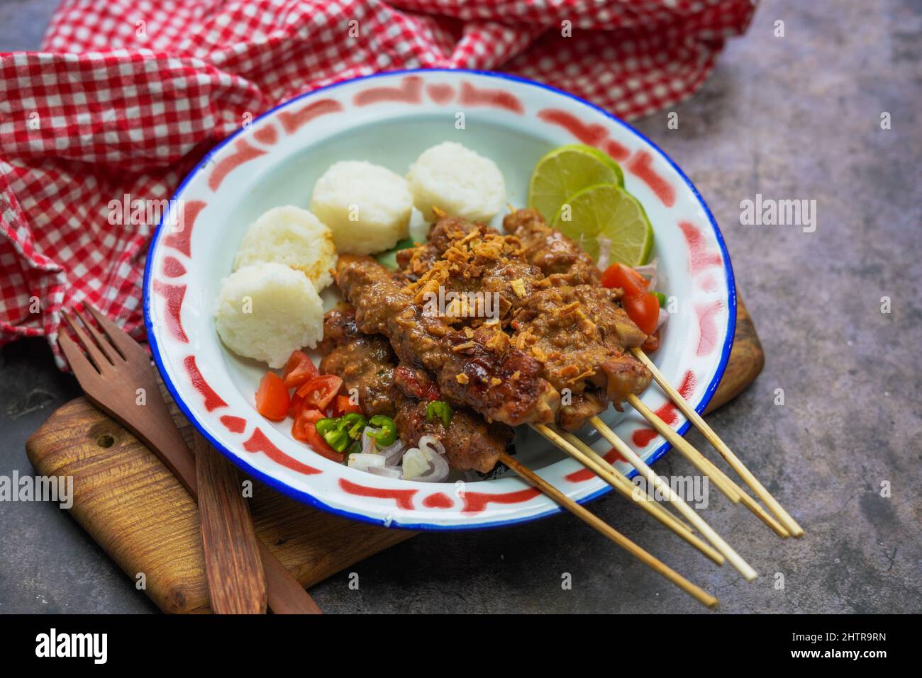 Cuisine indonésienne célèbre : sate ayam (poulet satay), servi avec une sauce aux arachides et un gâteau de riz ou lontong Banque D'Images