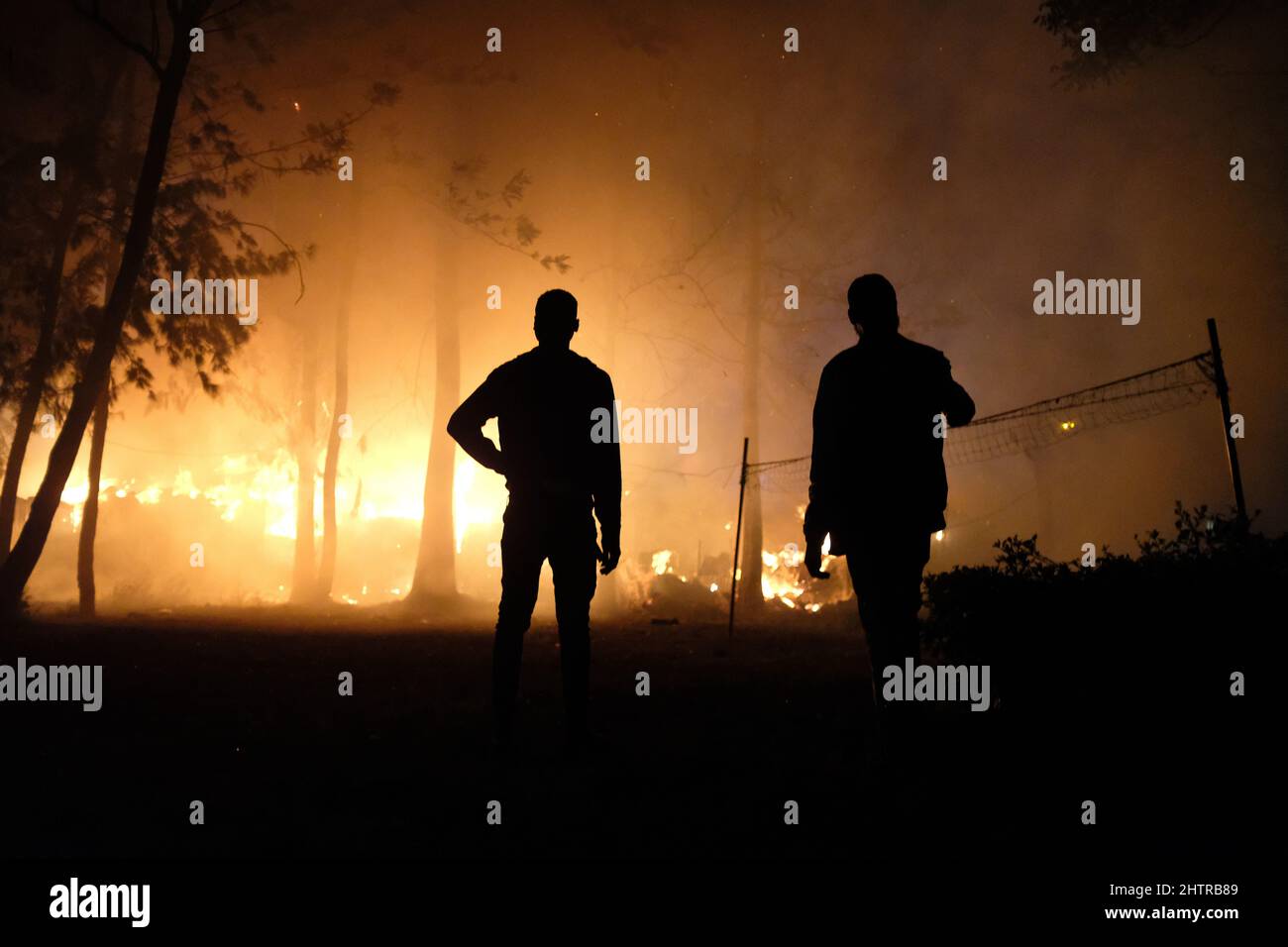 Nairobi, Kenya. 1st mars 2022. Les habitants de la région observent de loin le feu qui déforme les maisons et une forêt locale dans les bidonvilles de Kibera, Nairobi. Le 1st mars 2022. Les habitants des bidonvilles de Kibera ont subi une autre perte, car ils ont été pris au dépourvu par un incendie qui s'est produit tard dans la nuit, razzant vingt maisons, laissant la plupart des habitants sans abri et n'ayant nulle part où se tourner vers. L'incendie était dû à des fils emmêlés provenant de connexions électriques illégales. (Credit image: © Donwilson Odhiambo/ZUMA Press Wire) Banque D'Images