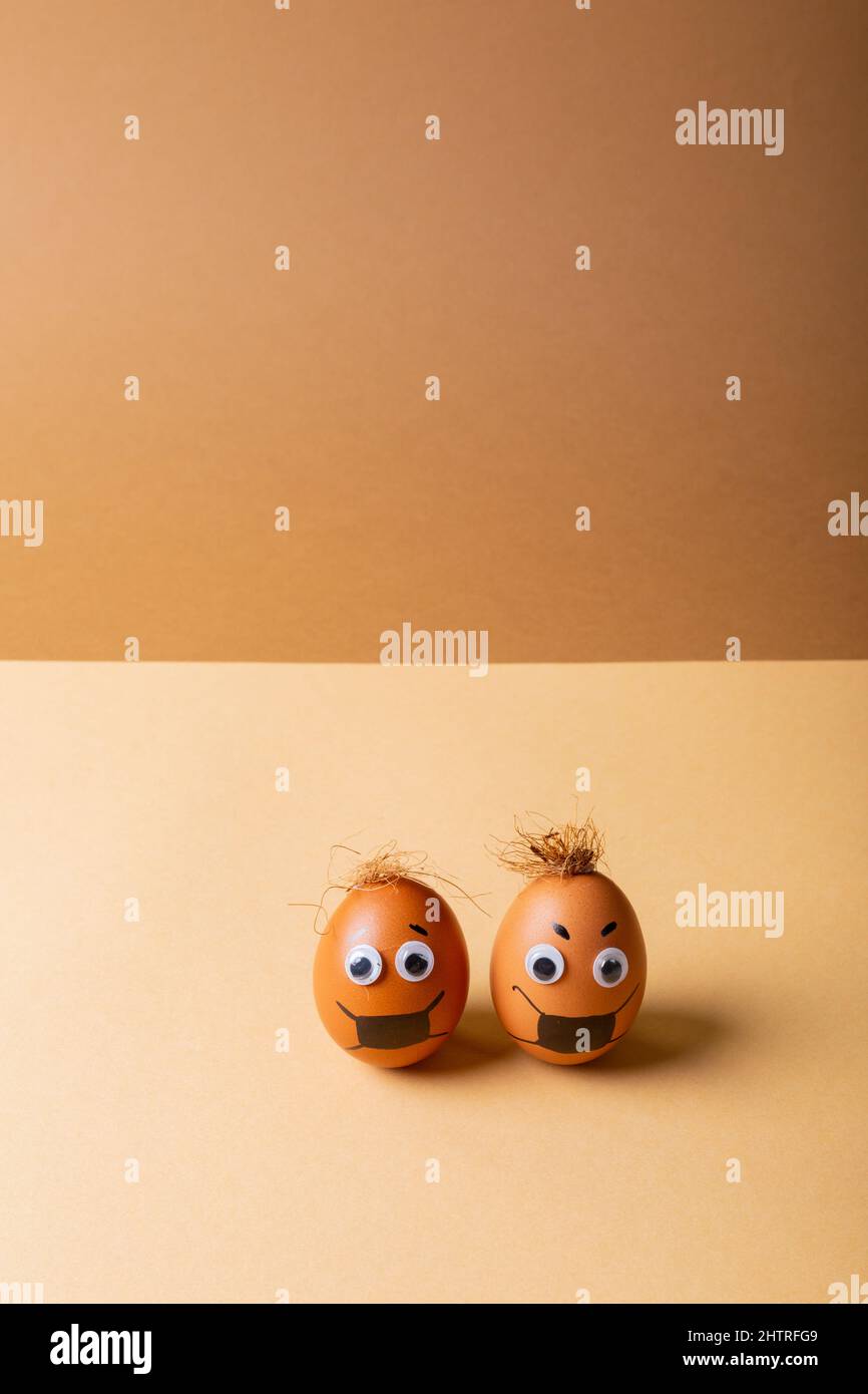 Oeufs de Pâques avec peinture de masque et les yeux d'oodle contre fond orange Banque D'Images