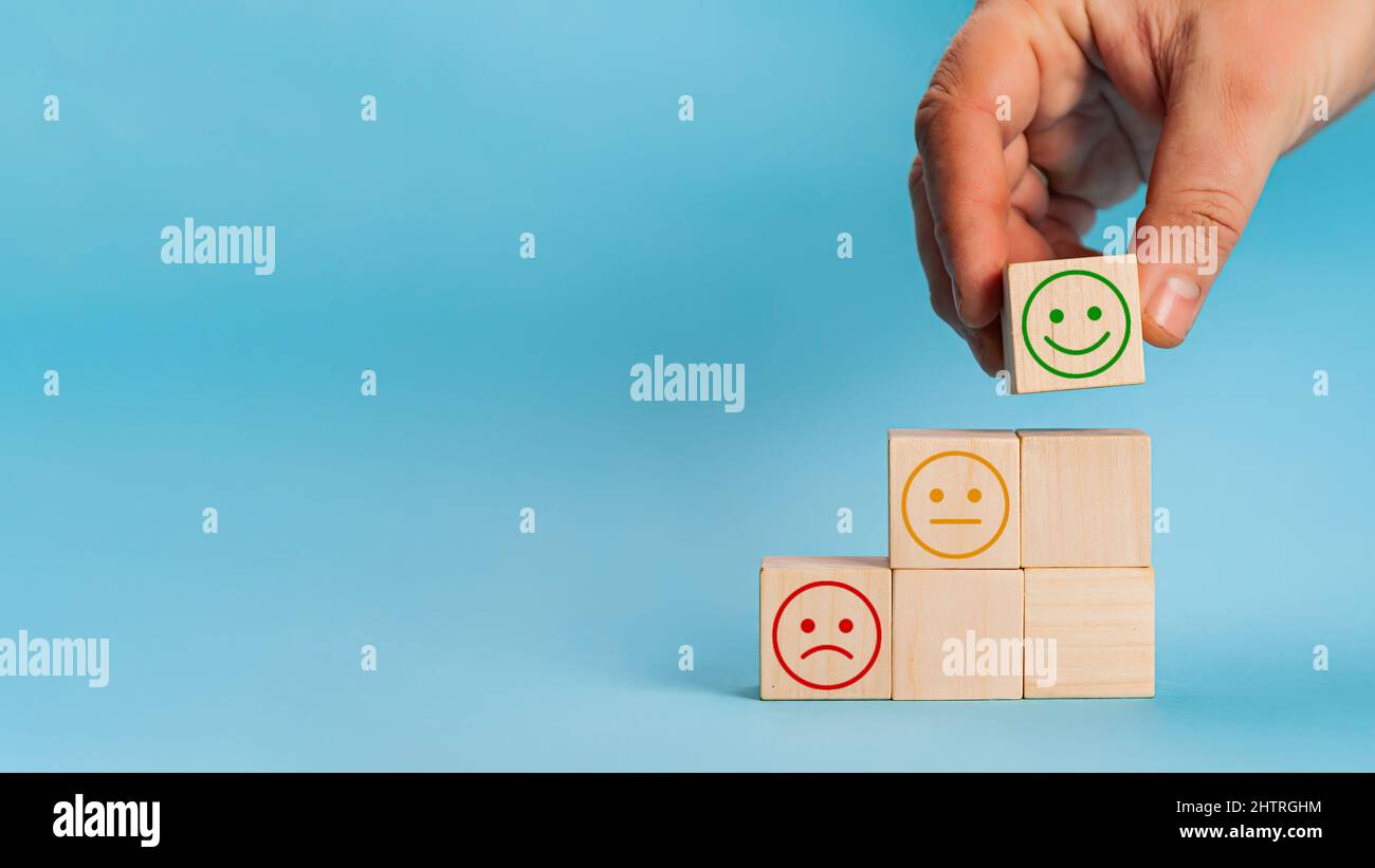 Main choisit smiley visage croissance sur le cube de bloc de bois, le meilleur exc Banque D'Images