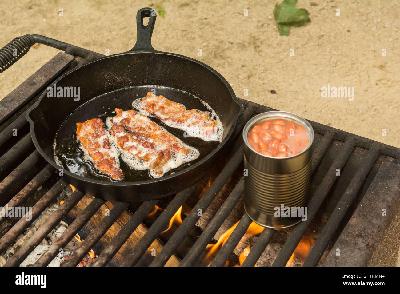 Cuisson du bacon avec des haricots cuits Banque D'Images