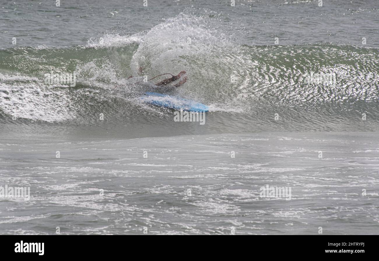 Surfeur a jeté de la planche à surf couverte d'une vague à Emerald Isle, Caroline du Nord Banque D'Images Surfeur a jeté de la planche à surf couverte d'une vague à Emerald Isle, Caroline du Nord Banque D'Images