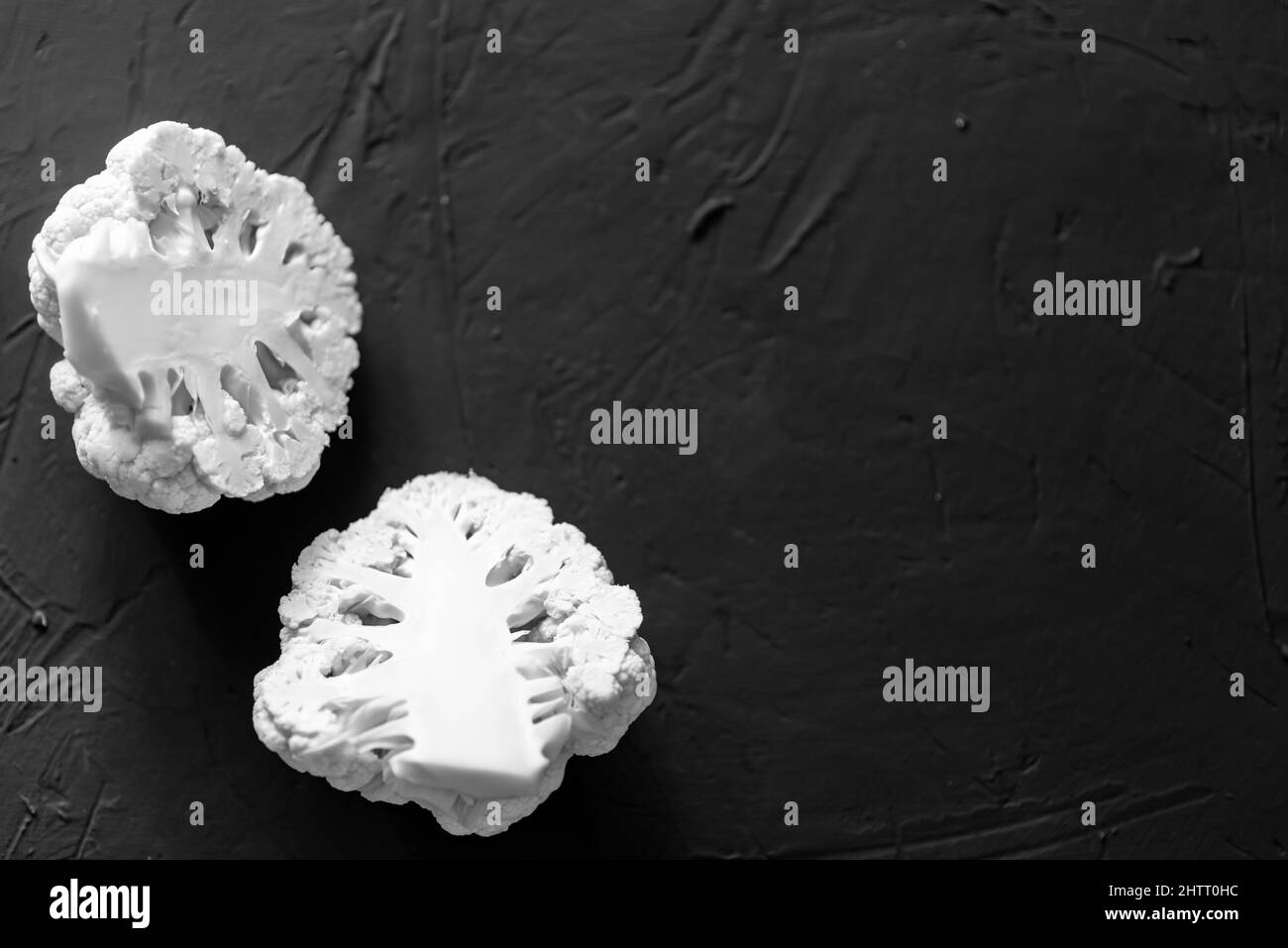 Chou-fleur coupé en deux sur fond sombre. Nourriture végétarienne, concept de régime. Banque D'Images