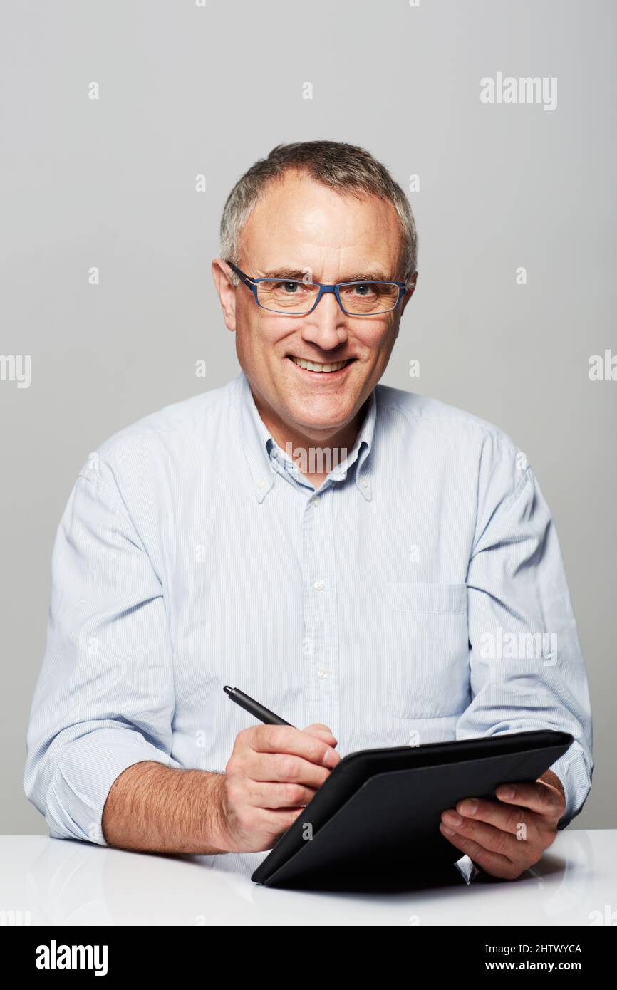 Il n'a jamais été aussi simple de rester organisé. Portrait en studio d'un homme mature travaillant sur une tablette numérique. Banque D'Images