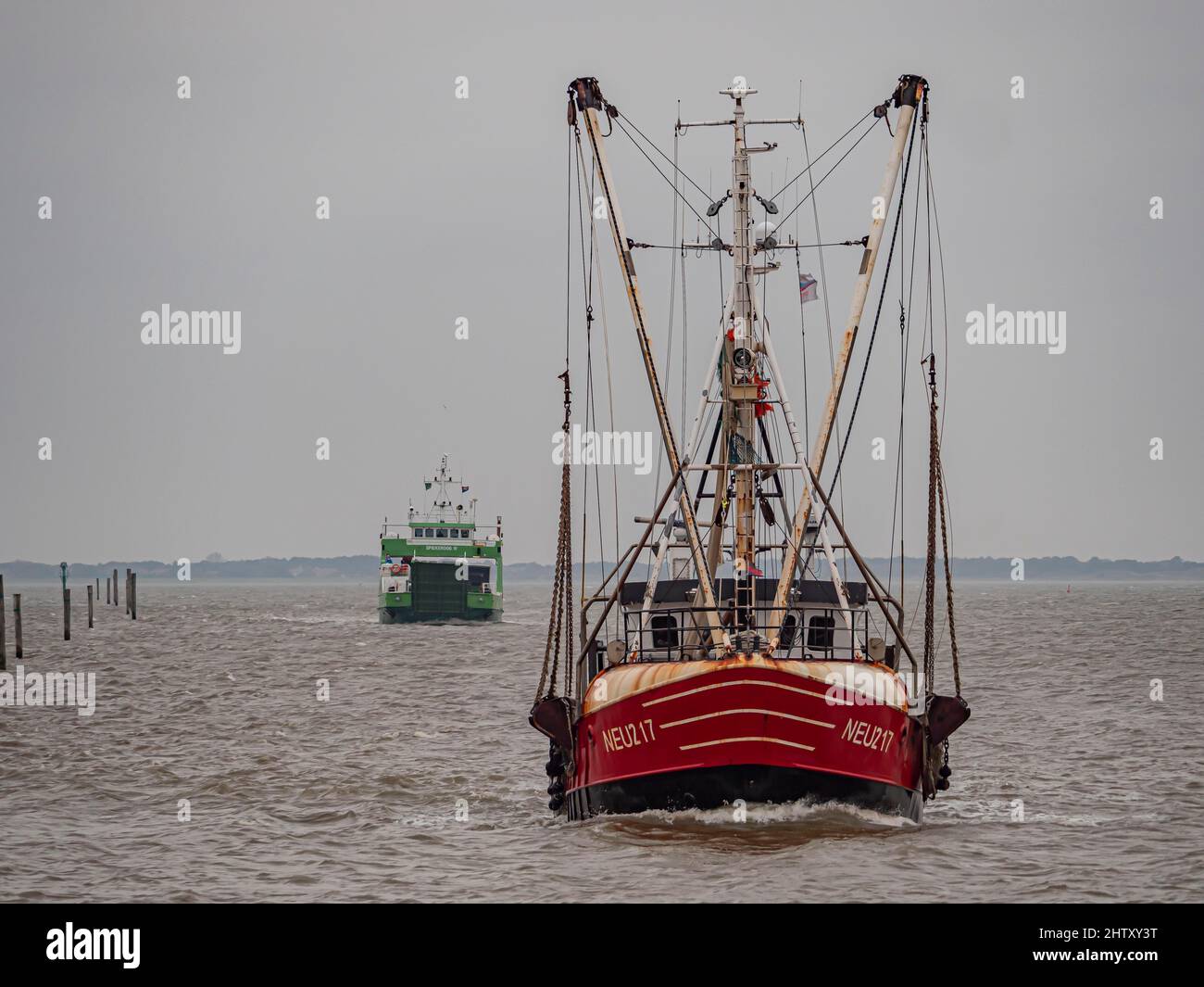 Coupe de crabe avec ferry Spiekeroog IVon la mer du Nord orageux entrant dans le port, Neuharlingersiel, Essens, Wittmund, Basse-Saxe, Allemagne Banque D'Images