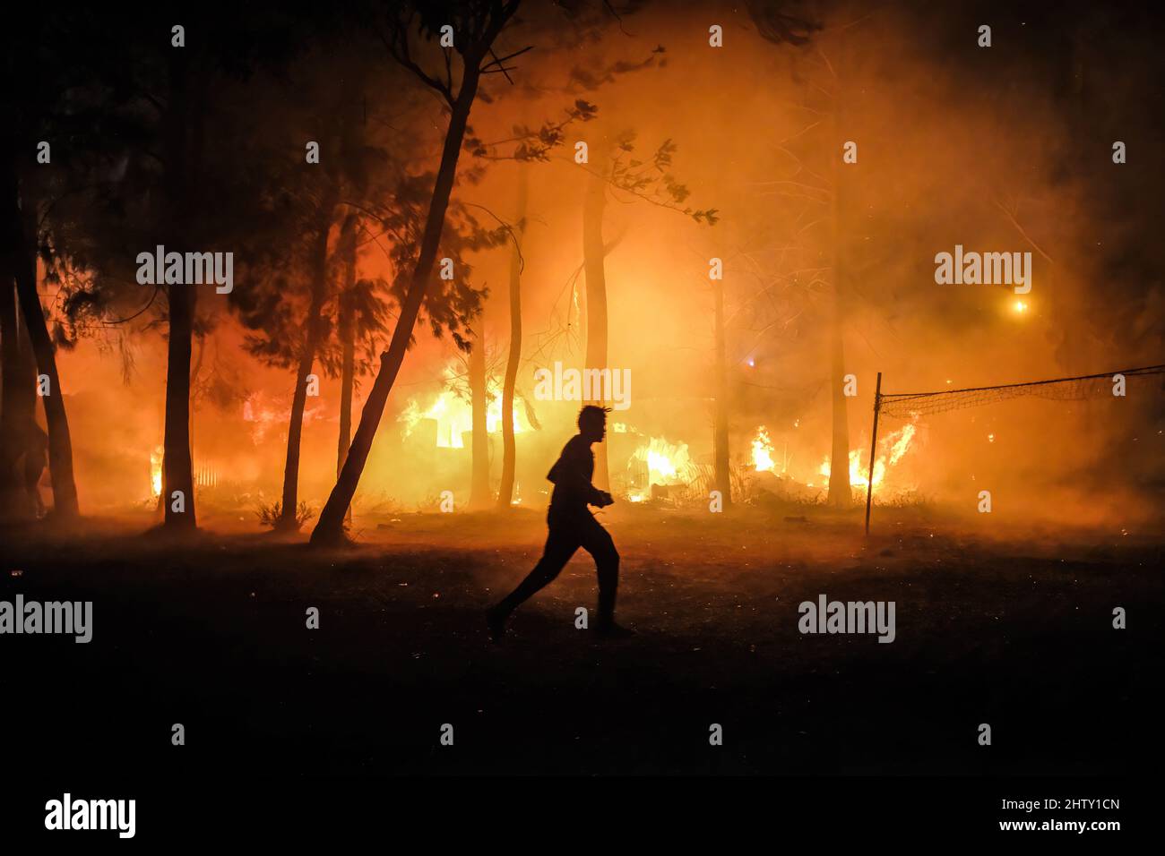 Nairobi, Kenya. 01st mars 2022. Un homme passe devant une forêt en feu pour aider les foyers lors d'une épidémie d'incendie dans les bidonvilles de Kibera, Nairobi. Les habitants des bidonvilles de Kibera ont subi une autre perte, car ils ont été pris au dépourvu par un incendie qui s'est produit tard dans la nuit, razzant vingt maisons, laissant la plupart des habitants sans abri et n'ayant nulle part où se tourner vers. L'incendie était dû à des fils emmêlés provenant de connexions électriques illégales. (Photo de Donwilson Odhiambo/SOPA Images/Sipa USA) crédit: SIPA USA/Alay Live News Banque D'Images