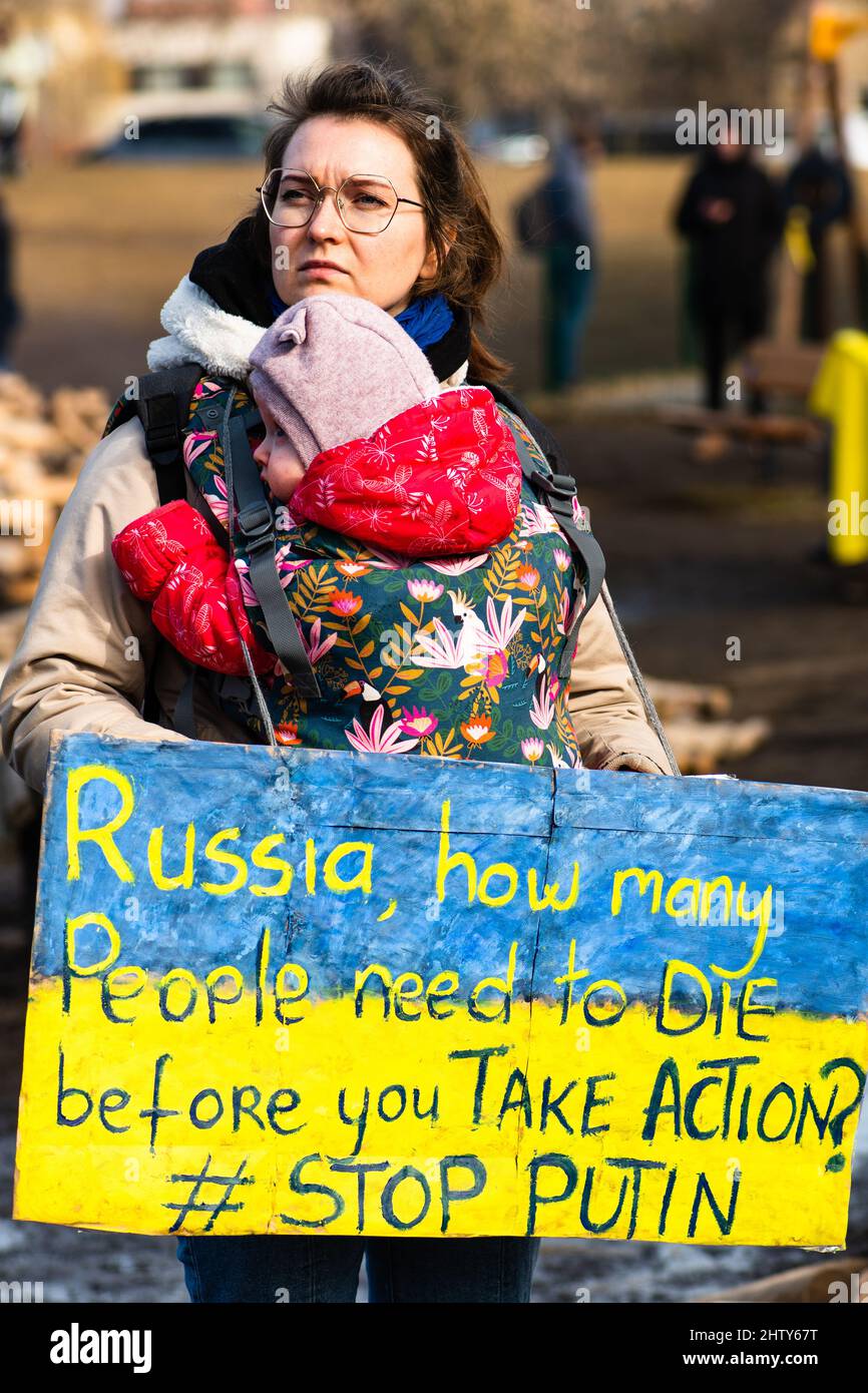 Fille avec bébé lors d'une manifestation pacifique contre la guerre, Poutine et la Russie en soutien à l'Ukraine, avec des gens, des pancartes et des drapeaux. Arrêter la guerre Banque D'Images