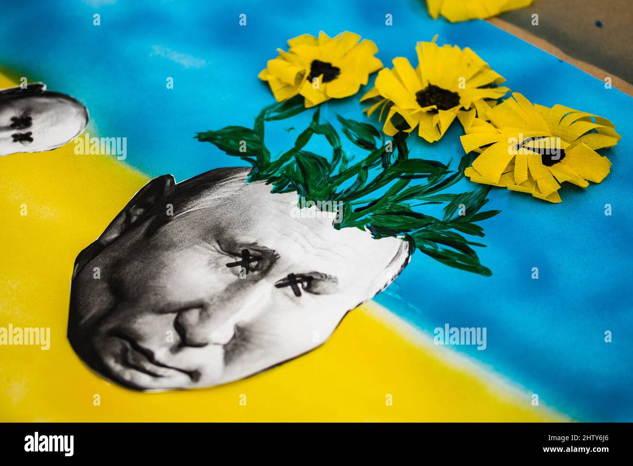 Manifestation pacifique contre la guerre à l'appui de l'Ukraine avec des placards, drapeaux, fleurs et bougies. Arrêter la guerre. Poutine mort avec des tournesols sur sa tête Banque D'Images