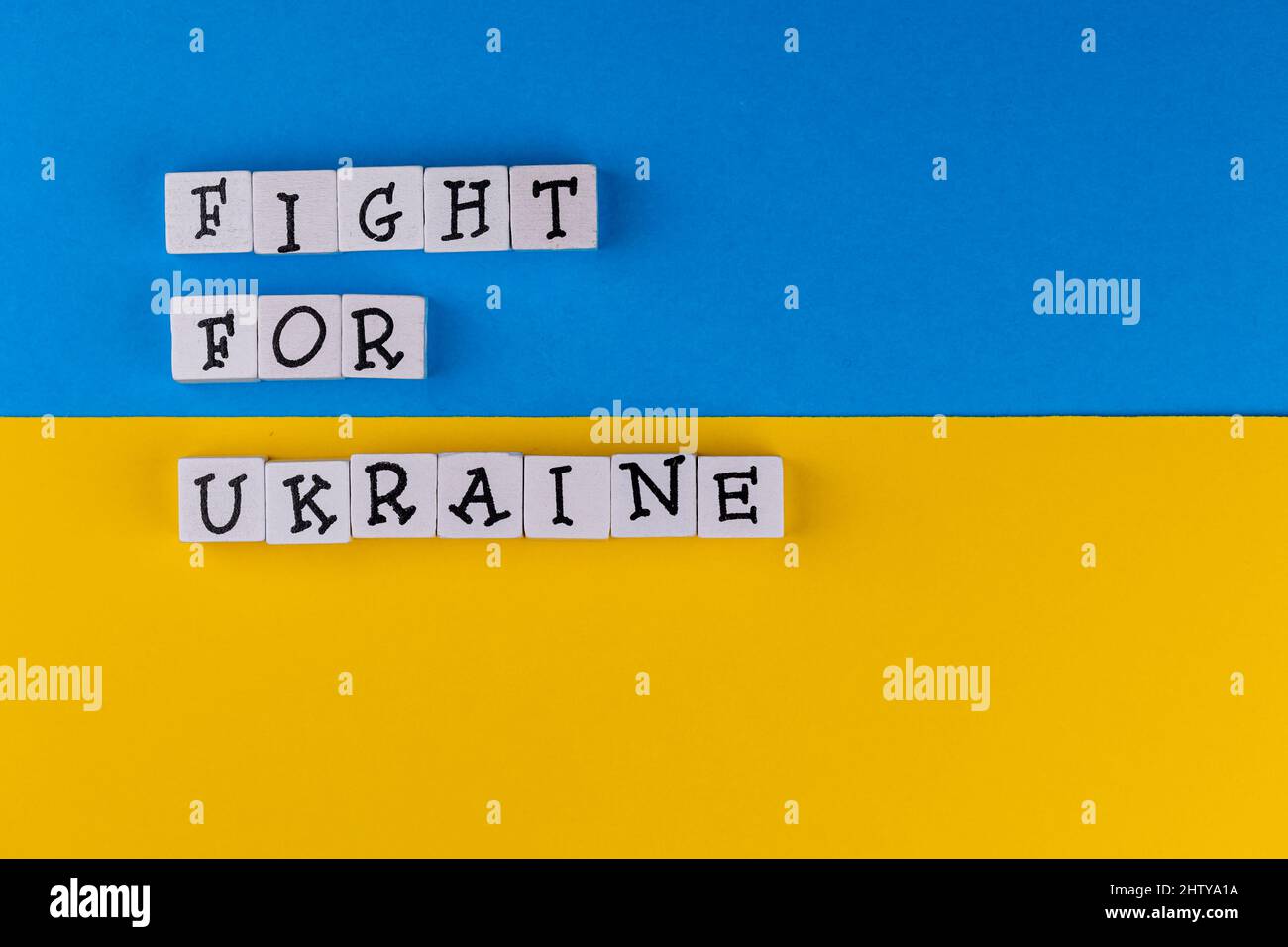 La phrase "lutte pour l'Ukraine" se compose de lettres sur fond de drapeau ukrainien. Photo prise sous une lumière artificielle douce Banque D'Images