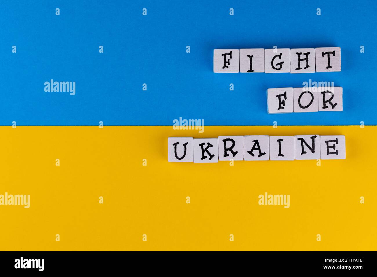 La phrase "lutte pour l'Ukraine" se compose de lettres sur fond de drapeau ukrainien. Photo prise sous une lumière artificielle douce Banque D'Images