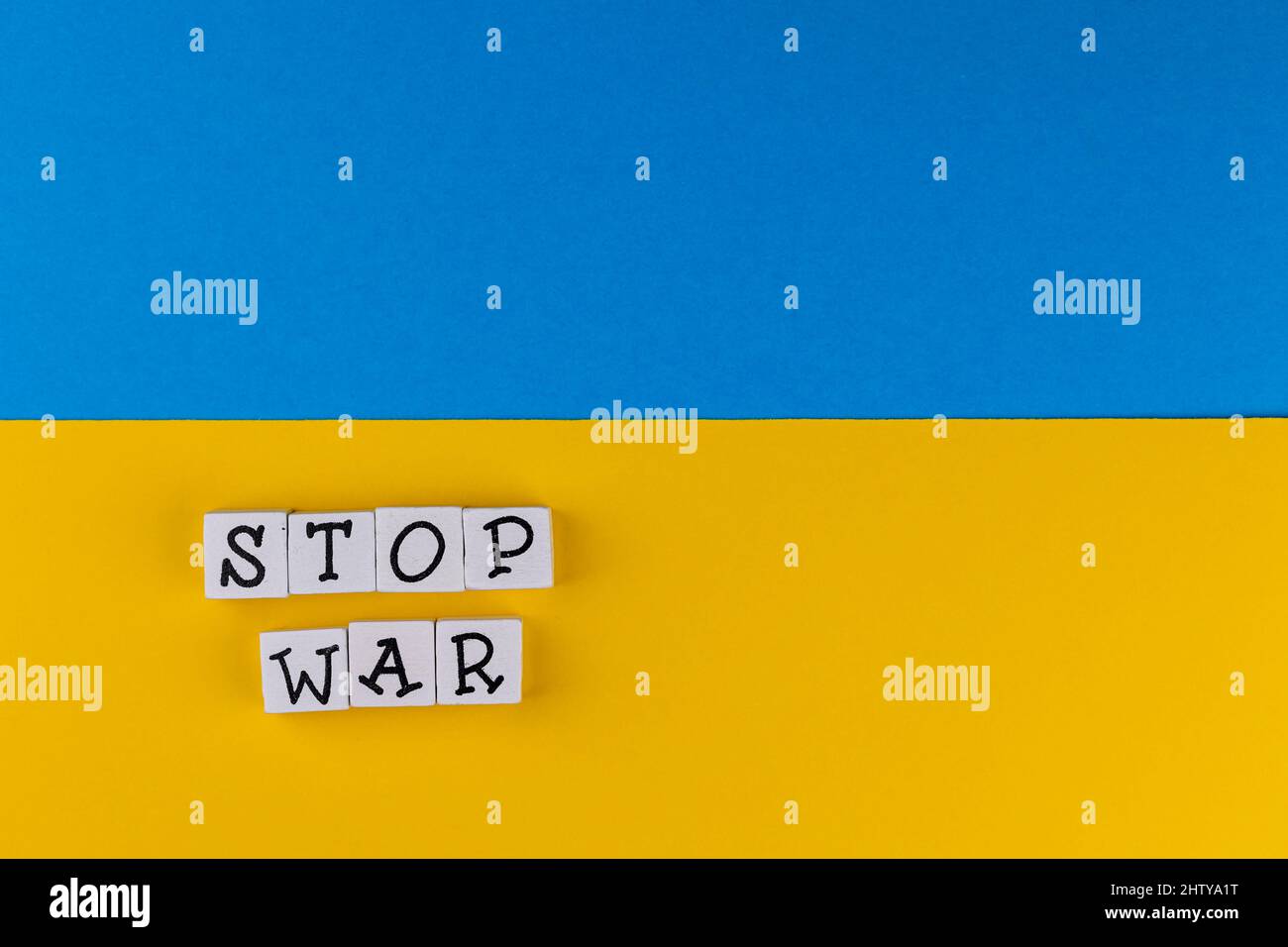 La phrase 'Stop War' se compose de lettres sur le fond du drapeau ukrainien. Photo prise sous une lumière artificielle douce Banque D'Images