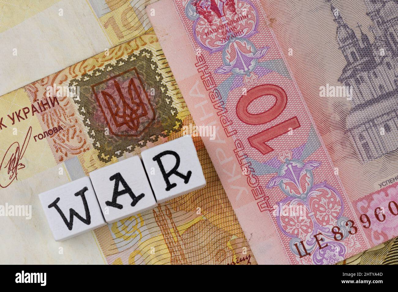 La phrase 'war' se compose de lettres sur le fond des billets ukrainiens. Photo prise sous une lumière artificielle douce Banque D'Images