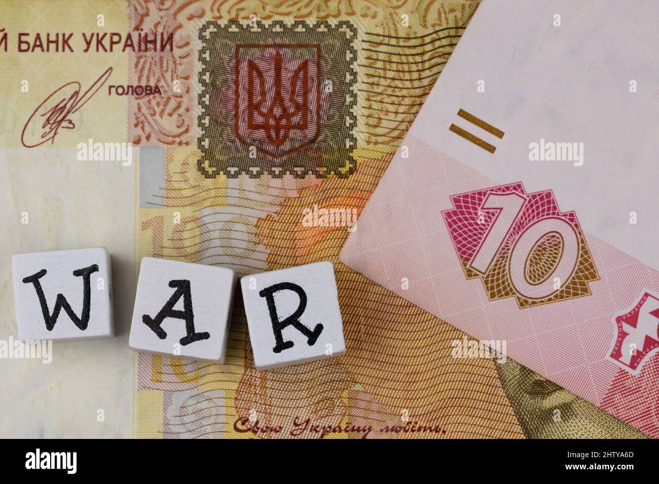 La phrase 'war' se compose de lettres sur le fond des billets ukrainiens. Photo prise sous une lumière artificielle douce Banque D'Images