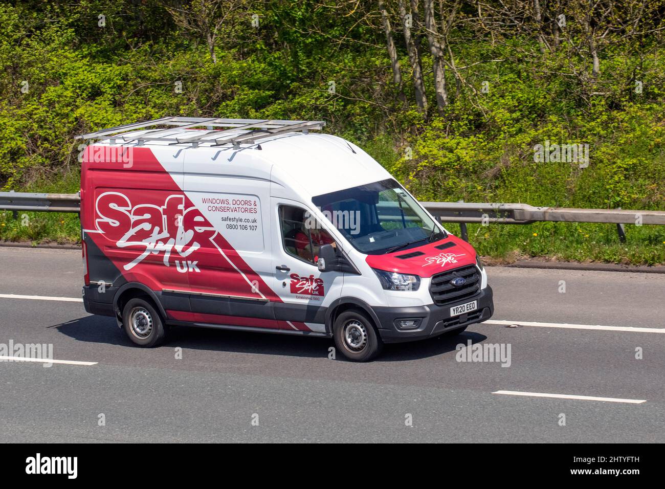 SafeStyle UK rouge blanc Ford Transit 2,0 Ecoblue 130ps H2 leader Van Panel Van 350 l3 diesel RWD 1995cc 6 vitesses H ; fenêtres, portes et conservatoires installateur conduisant sur l'autoroute M61. Banque D'Images