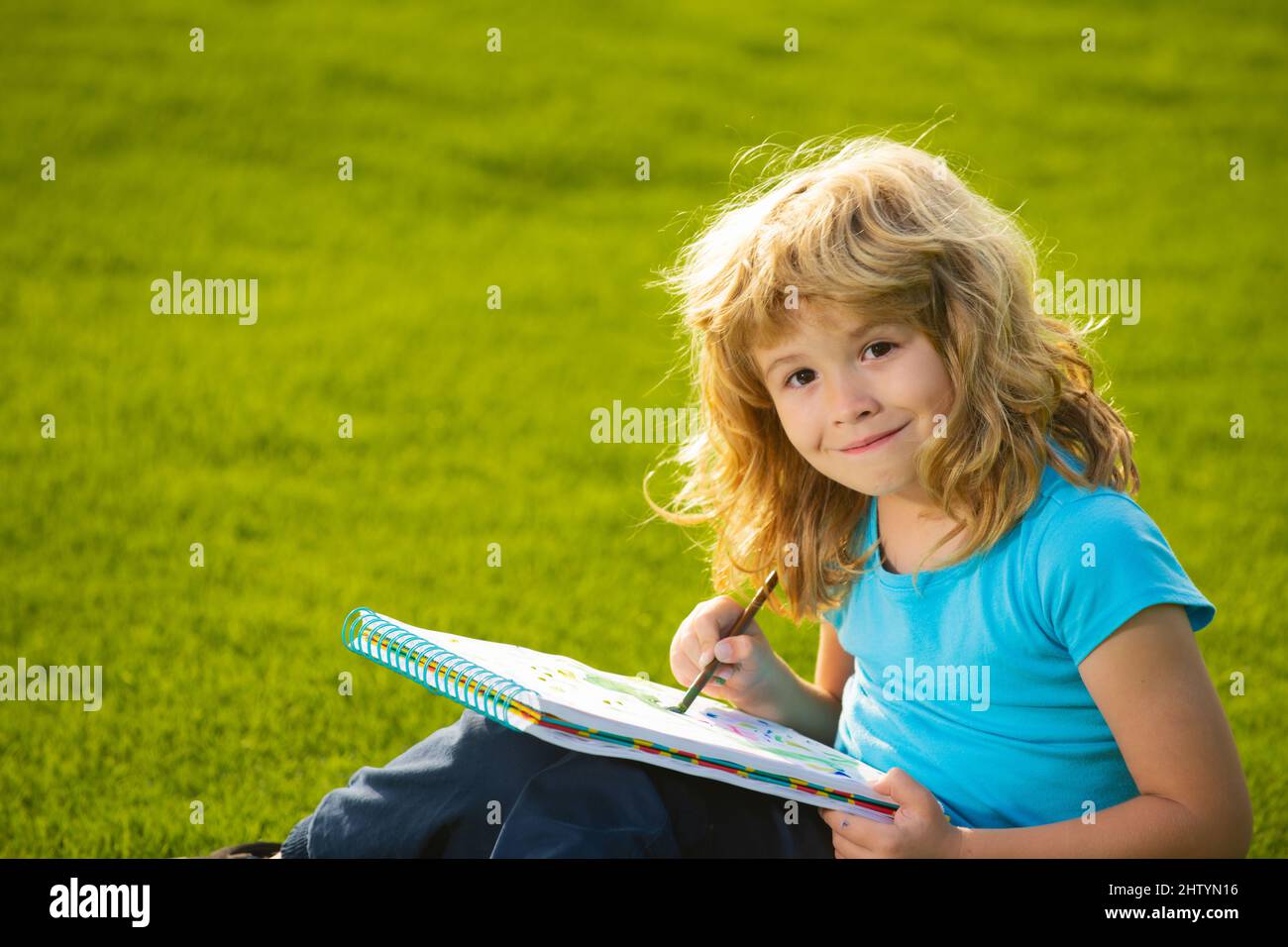 Enfant garçon attire dans le parc en s'amusant sur fond de nature. Enfant heureux jouant à l'extérieur. Dessin du thème d'été. Imagination pour enfants. Banque D'Images