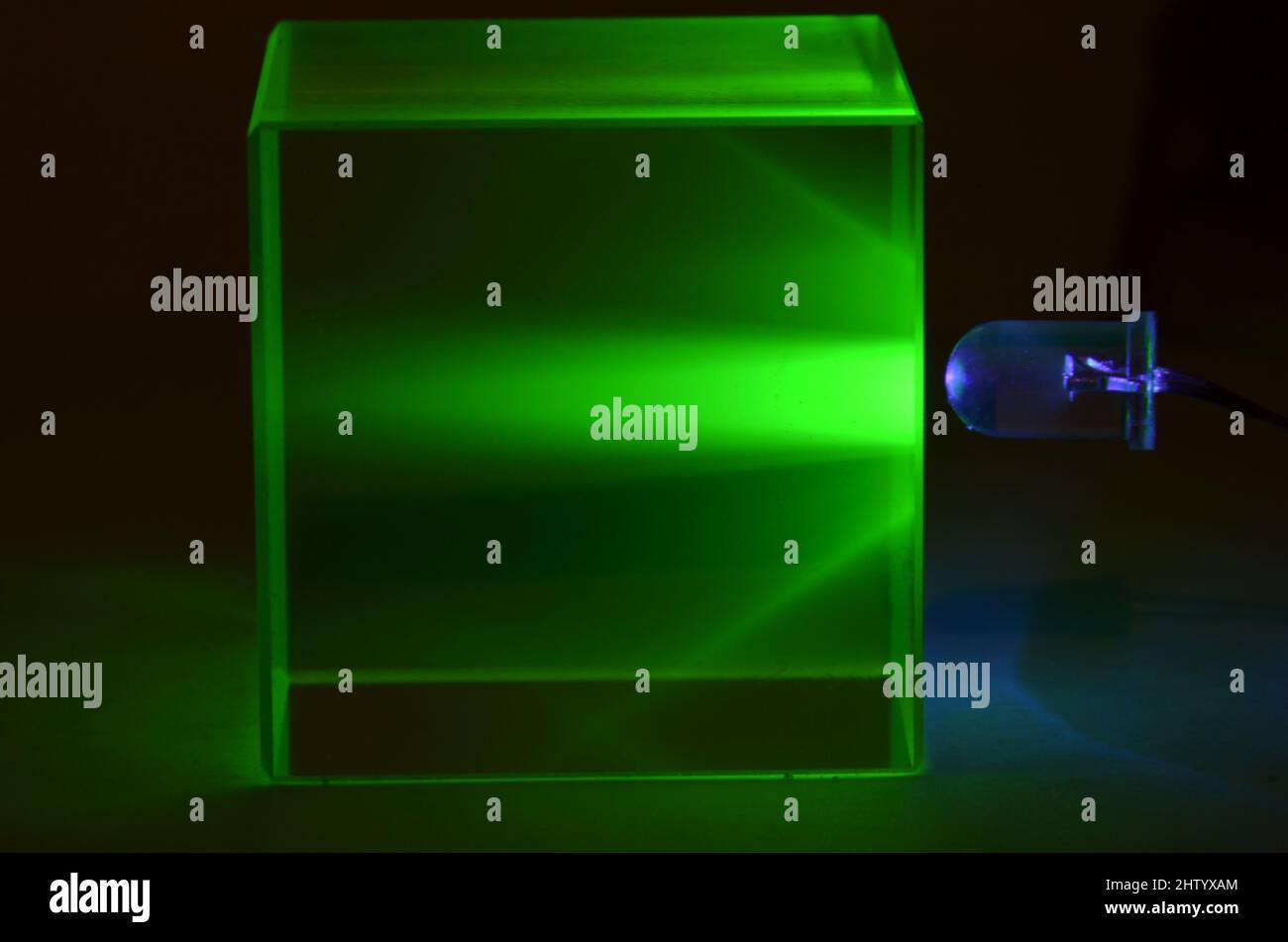 La lumière de la LED UV traverse un bloc de verre d'uranium Banque D'Images