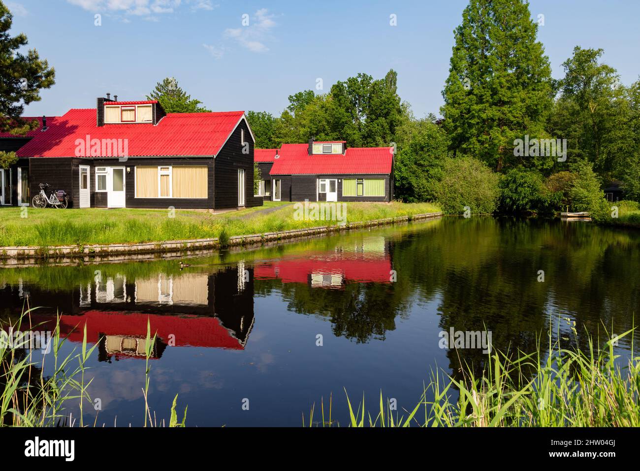 Petites maisons de vacances confortables avec des toits rouges reflétés dans l'eau Banque D'Images