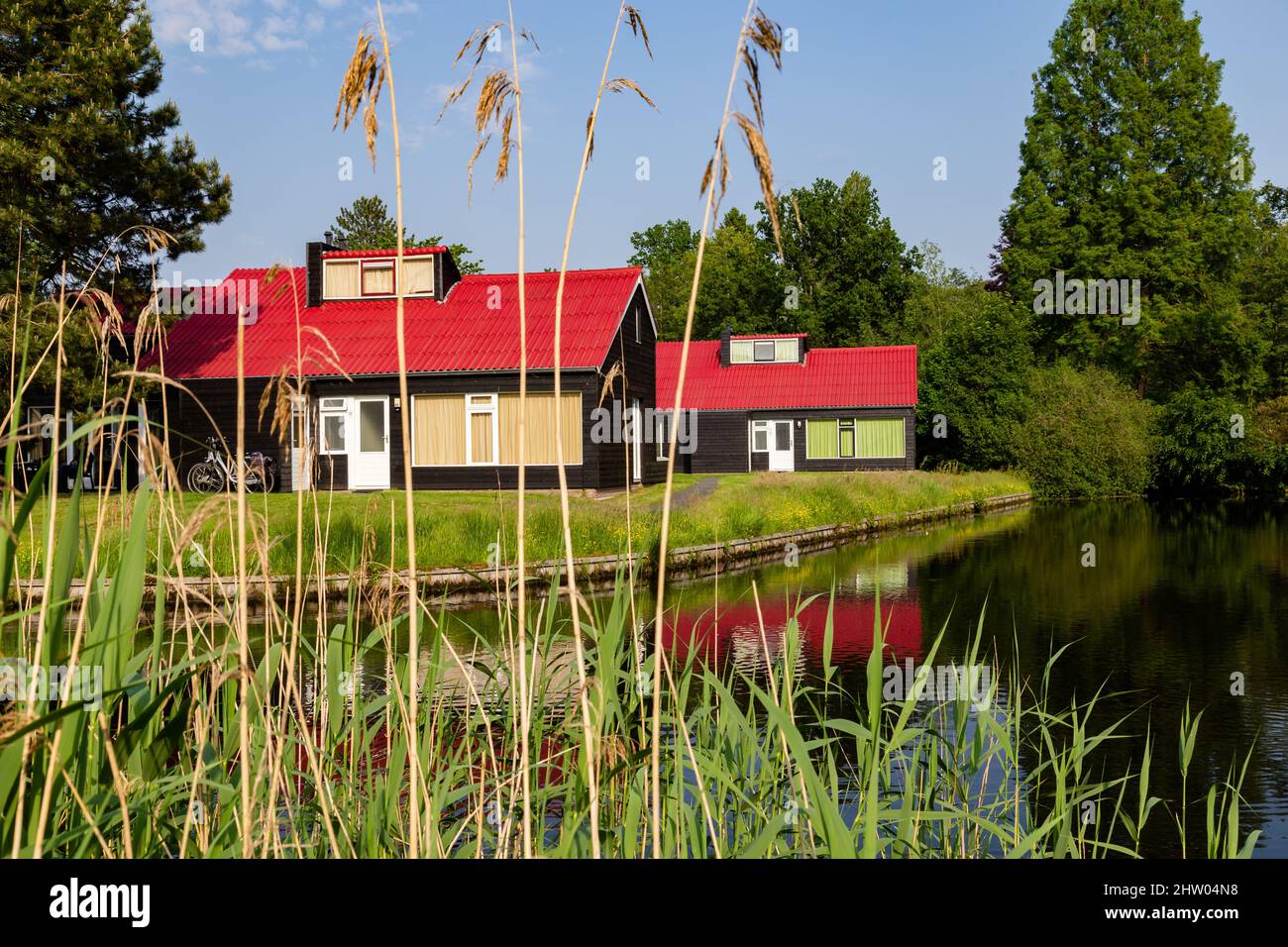 Petites maisons de vacances confortables avec des toits rouges reflétés dans l'eau Banque D'Images