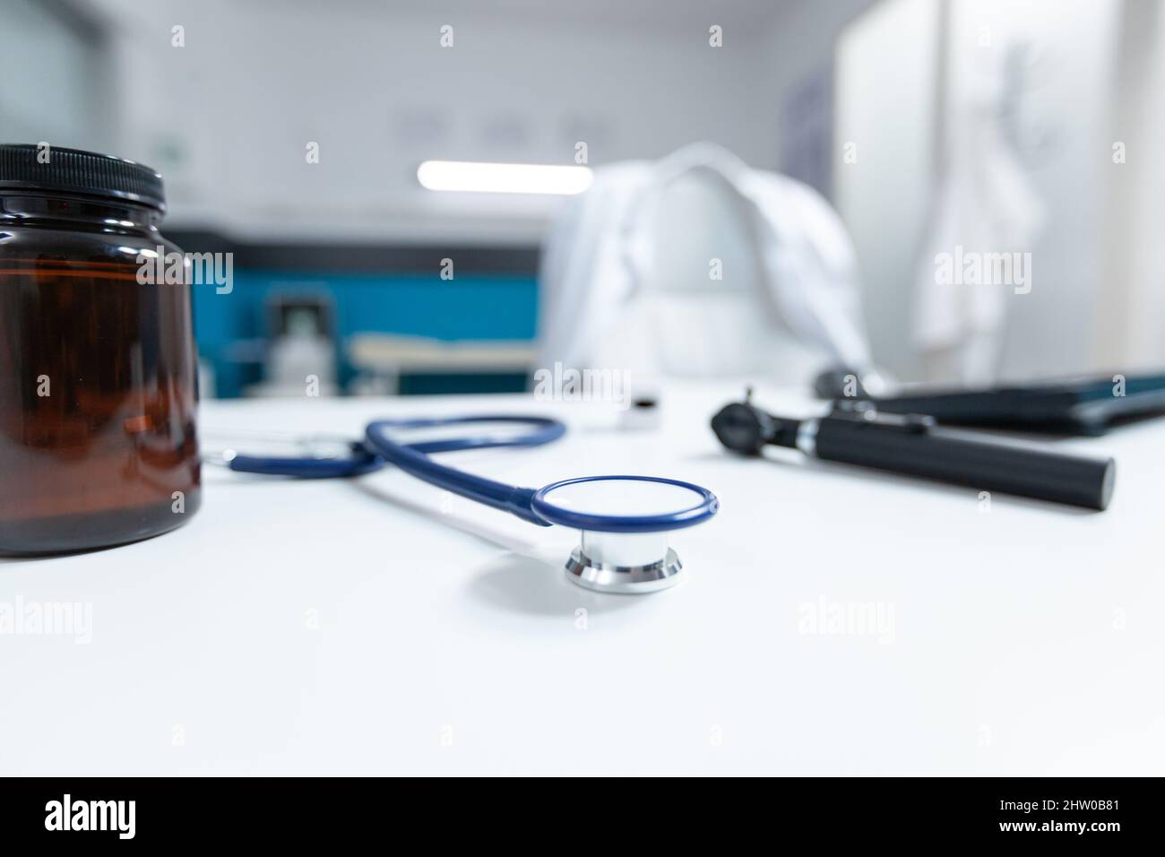 Accent sélectif sur le stéthoscope médical debout sur une table prête pour la consultation de la maladie. Vide bureau de médecin avec personne dans lui équipé d'outils d'examen professionnels. Concept de médecine Banque D'Images