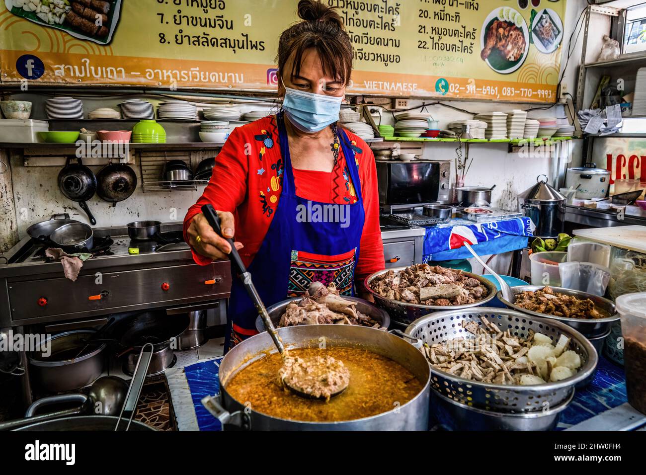 Bangkok, Thaïlande. 04th mars 2022. Un vendeur masqué est vu faire du curry thaïlandais dans sa rue de nourriture stall à Bangkok. La Thaïlande s'ouvre à nouveau aux touristes internationaux pleinement vaccinés en assouplissant les restrictions à 'Test and Go, ' son programme d'entrée sans quarantaine. Crédit : SOPA Images Limited/Alamy Live News Banque D'Images