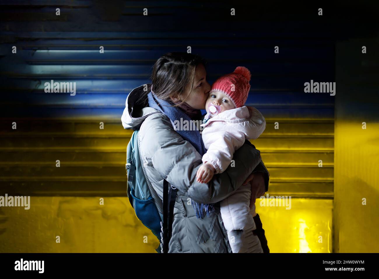 Une mère aimante tenant son enfant dans ses bras dans le refuge souterrain Banque D'Images