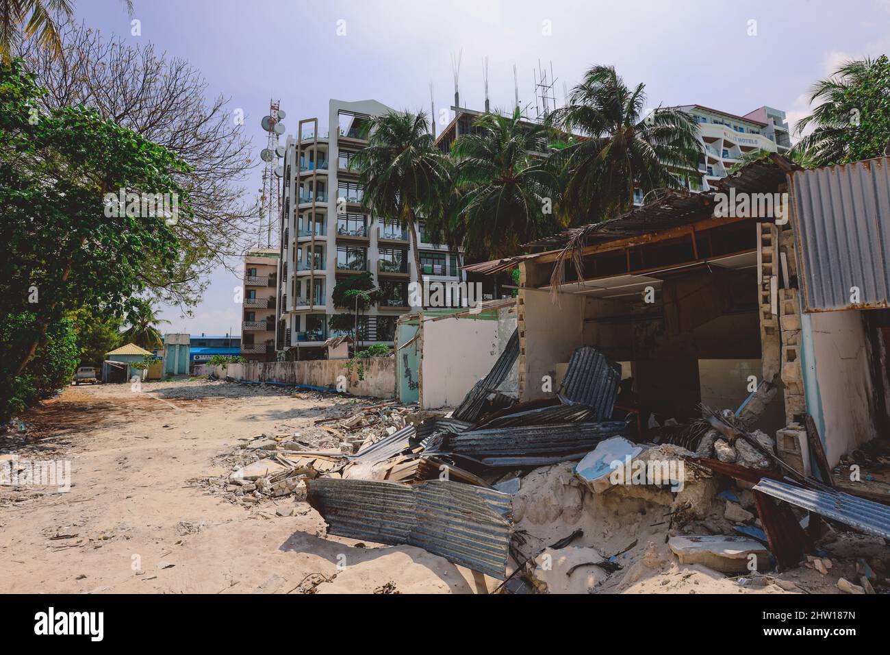 Ruines des maisons en bois avec le bâtiment de l'hôtel maldivien sur le fond, l'île de Maafushi Banque D'Images