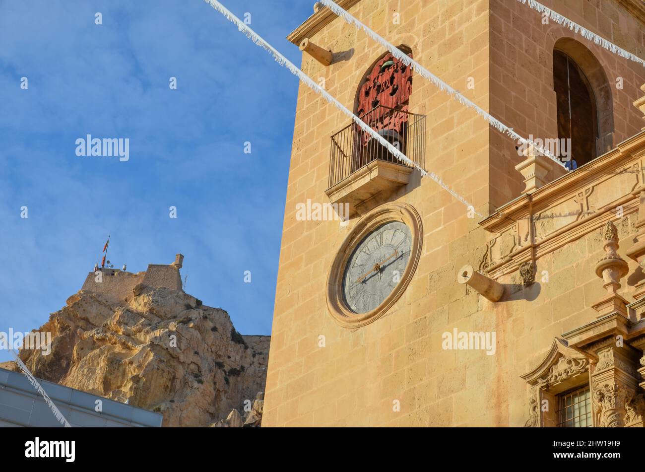 Tour d'horloge artistique de la basilique Sainte-Marie d'Alicante. En arrière-plan le Castillo de Santa Bárbara sur une montagne sous ciel bleu clair. Valen Banque D'Images