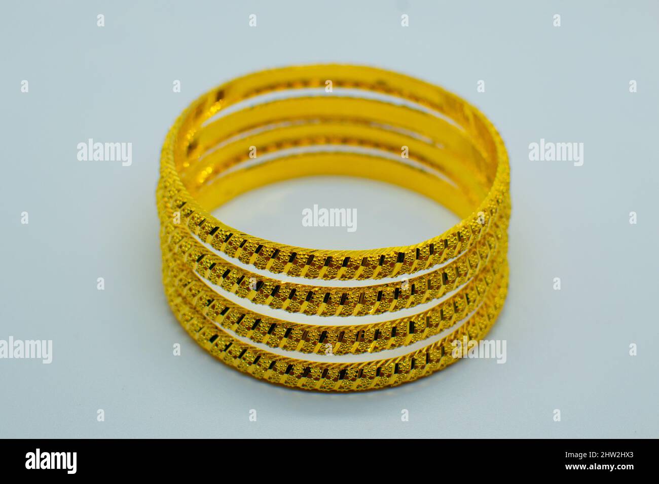 Gros plan des bracelets dorés isolés sur fond gris. Banque D'Images