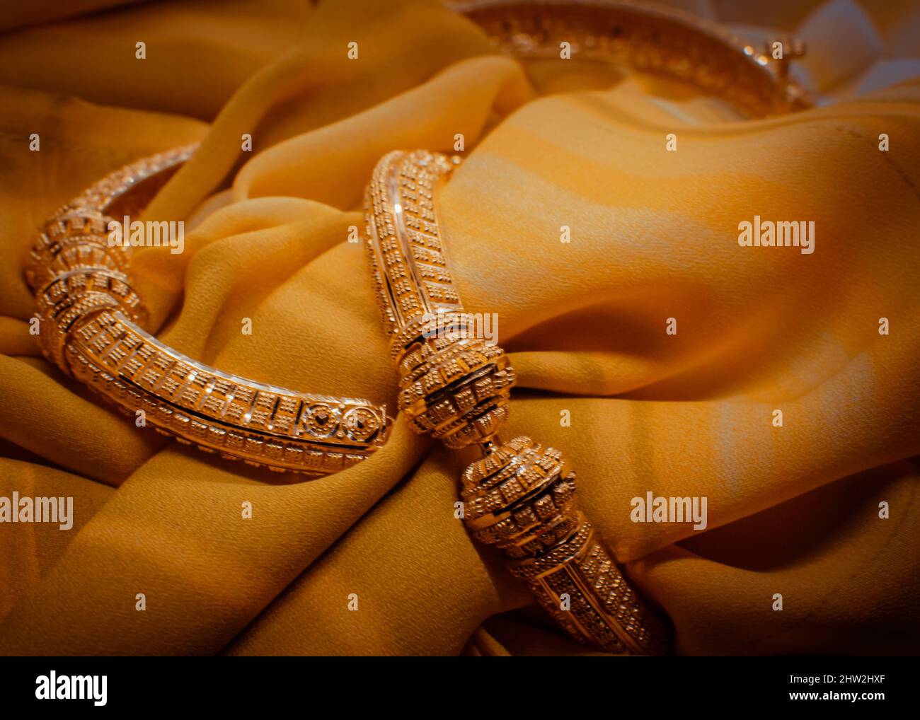 Gros plan des bracelets dorés sur le tissu. Banque D'Images