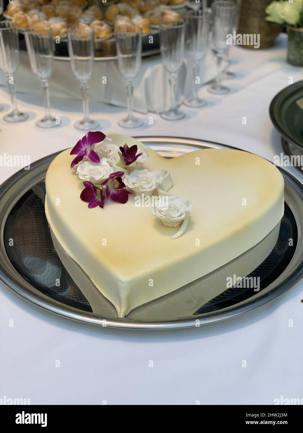 Photo verticale d'un gâteau de mariage en forme de cœur sur un plateau argenté Banque D'Images