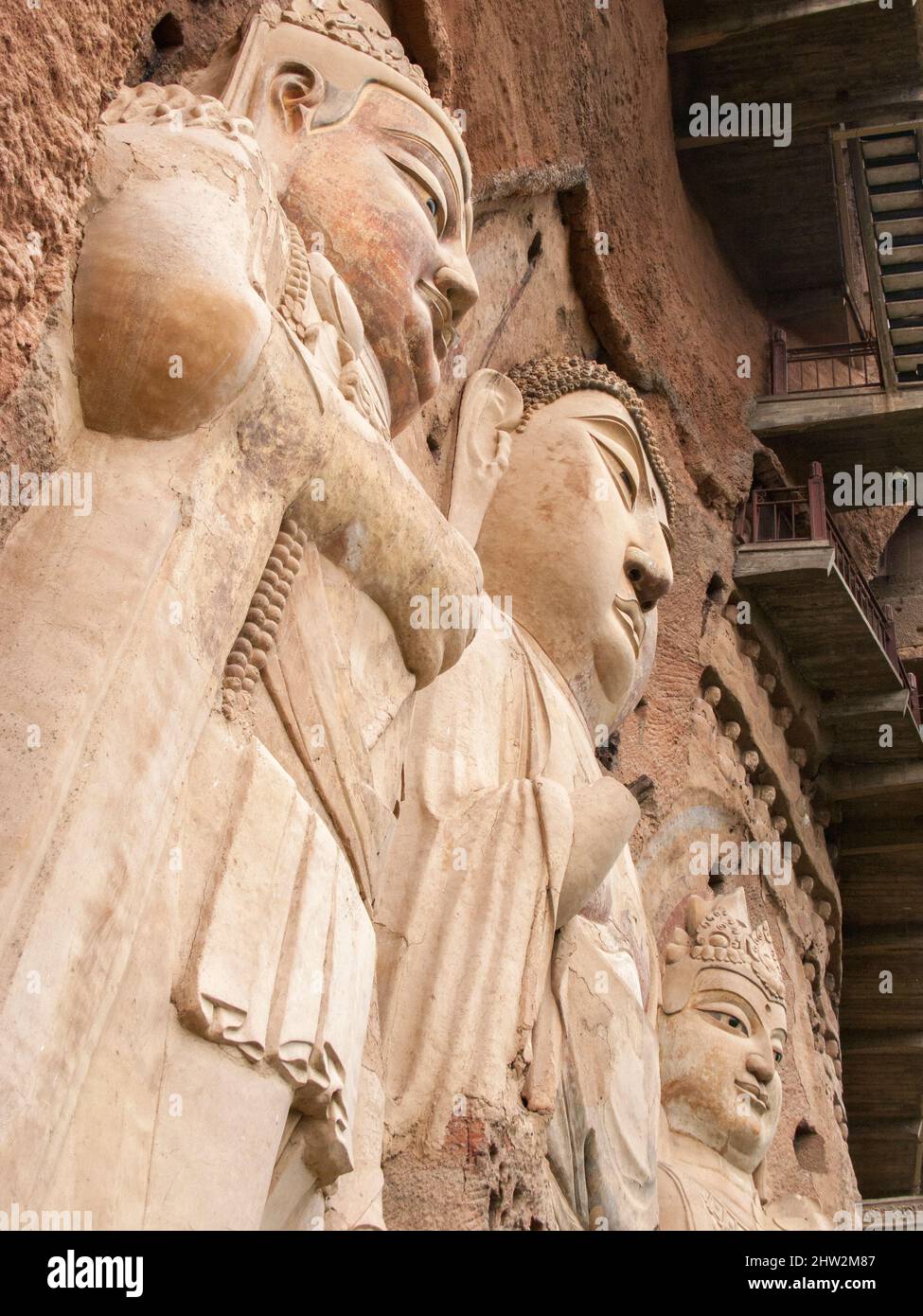 Représentations de Bouddha figures représentations et images bouddhistes (qui semble être restauré très récemment à l'aide de nouveaux matériaux) sur la face rocheuse des grottes de Maijishan, autrefois romanisée comme Maichishan, Qui sont une série de 194 grottes coupées sur le flanc de la colline de Majishan à Tianshui, province de Gansu, Chine. Des escaliers et des passerelles sont fixés à la face de roche pure pour permettre aux visiteurs d'entrer en contact étroit avec les figures d'argile et les anciennes sculptures en pierre sur le site. (67/125) Banque D'Images