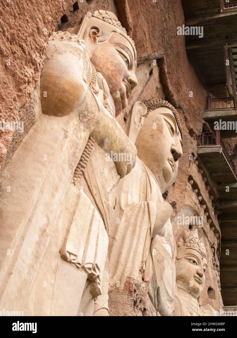 Représentations de Bouddha figures représentations et images bouddhistes (qui semble être restauré très récemment à l'aide de nouveaux matériaux) sur la face rocheuse des grottes de Maijishan, autrefois romanisée comme Maichishan, Qui sont une série de 194 grottes coupées sur le flanc de la colline de Majishan à Tianshui, province de Gansu, Chine. Des escaliers et des passerelles sont fixés à la face de roche pure pour permettre aux visiteurs d'entrer en contact étroit avec les figures d'argile et les anciennes sculptures en pierre sur le site. (67/125) Banque D'Images