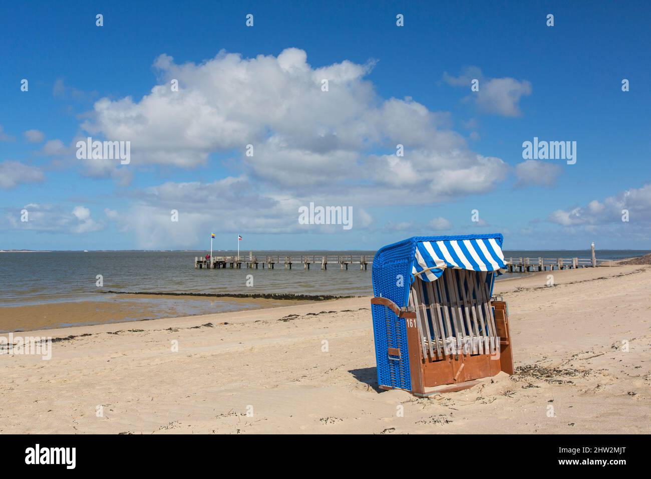Chaise de plage couverte en osier et jetée en bois à Utersum sur l'île de Föhr dans le district de Nordfriesland, Schleswig-Holstein, Allemagne Banque D'Images