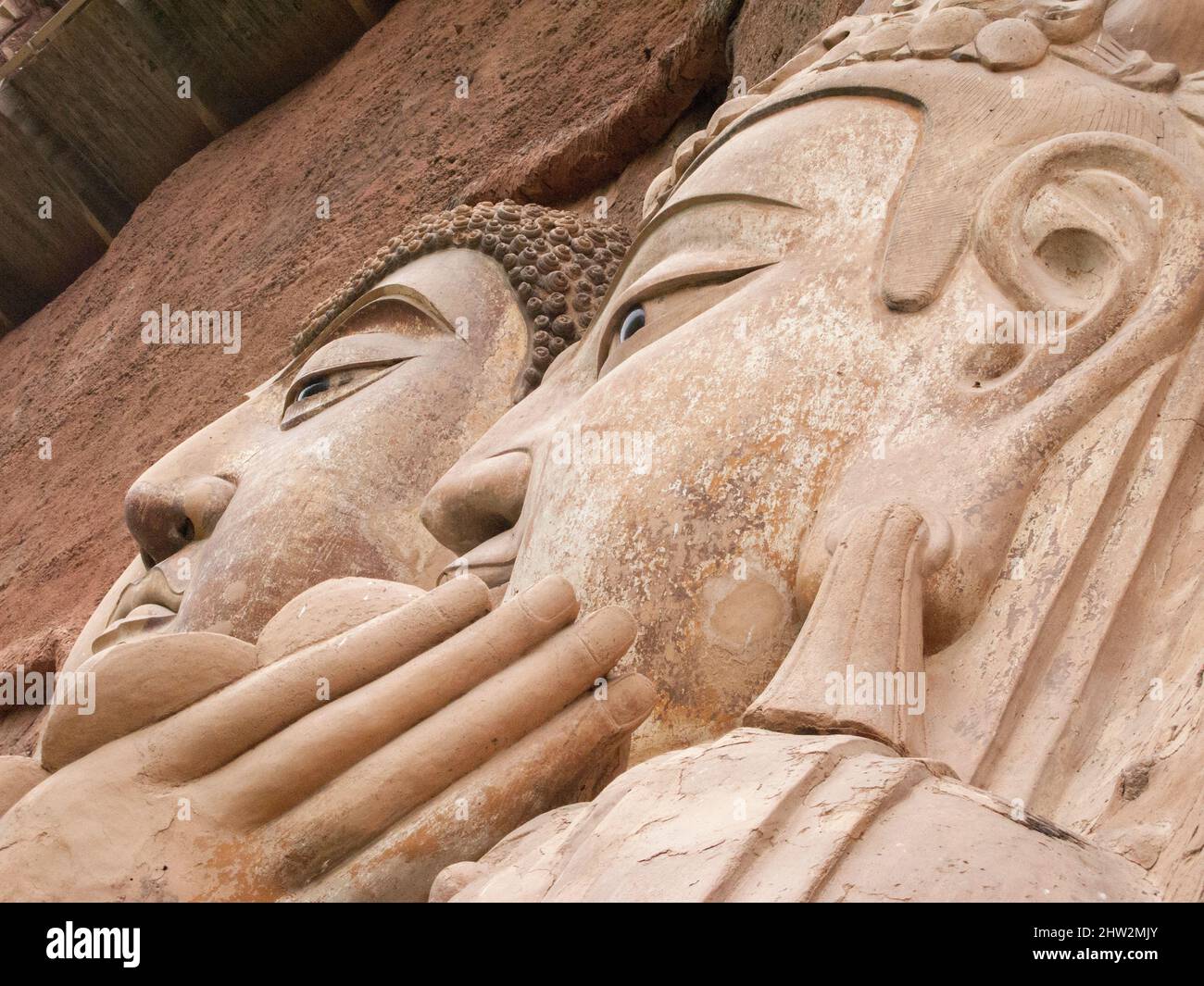 Représentations de Bouddha figures représentations et images bouddhistes (qui semble être restauré très récemment à l'aide de nouveaux matériaux) sur la face rocheuse des grottes de Maijishan, autrefois romanisée comme Maichishan, Qui sont une série de 194 grottes coupées sur le flanc de la colline de Majishan à Tianshui, province de Gansu, Chine. Des escaliers et des passerelles sont fixés à la face de roche pure pour permettre aux visiteurs d'entrer en contact étroit avec les figures d'argile et les anciennes sculptures en pierre sur le site. (67/125) Banque D'Images