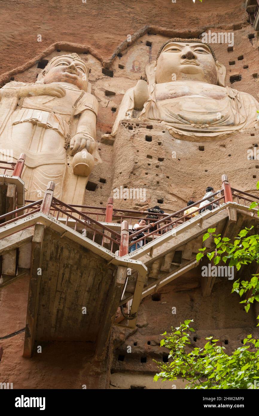 Représentations de Bouddha figures représentations et images bouddhistes (qui semble être restauré très récemment à l'aide de nouveaux matériaux) sur la face rocheuse des grottes de Maijishan, autrefois romanisée comme Maichishan, Qui sont une série de 194 grottes coupées sur le flanc de la colline de Majishan à Tianshui, province de Gansu, Chine. Des escaliers et des passerelles sont fixés à la face de roche pure pour permettre aux visiteurs d'entrer en contact étroit avec les figures d'argile et les anciennes sculptures en pierre sur le site. (67/125) Banque D'Images