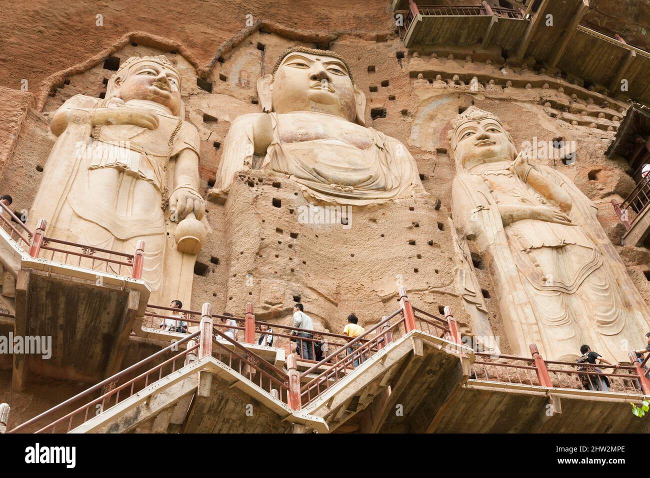 Représentations de Bouddha figures représentations et images bouddhistes (qui semble être restauré très récemment à l'aide de nouveaux matériaux) sur la face rocheuse des grottes de Maijishan, autrefois romanisée comme Maichishan, Qui sont une série de 194 grottes coupées sur le flanc de la colline de Majishan à Tianshui, province de Gansu, Chine. Des escaliers et des passerelles sont fixés à la face de roche pure pour permettre aux visiteurs d'entrer en contact étroit avec les figures d'argile et les anciennes sculptures en pierre sur le site. (67/125) Banque D'Images