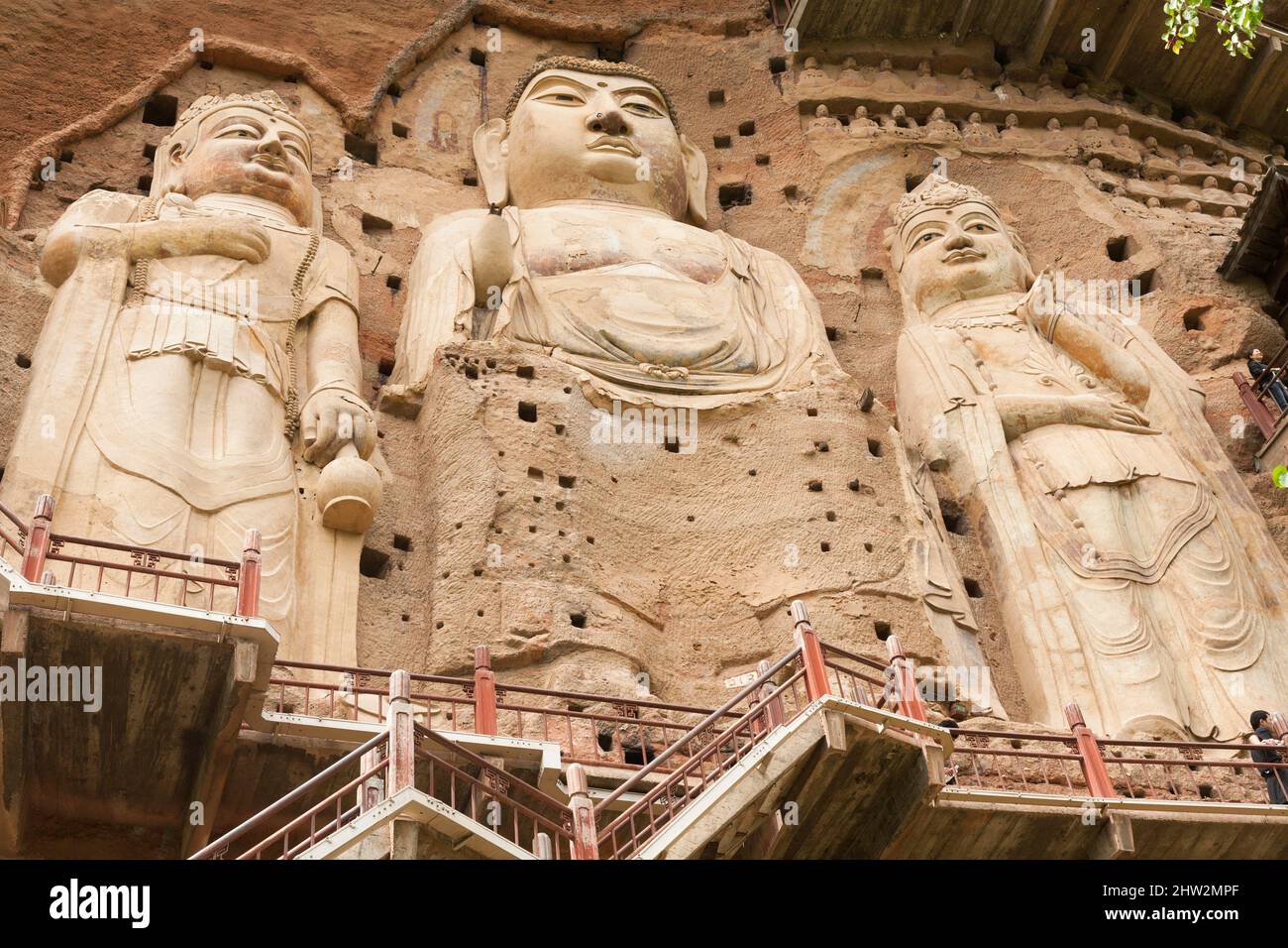 Représentations de Bouddha figures représentations et images bouddhistes (qui semble être restauré très récemment à l'aide de nouveaux matériaux) sur la face rocheuse des grottes de Maijishan, autrefois romanisée comme Maichishan, Qui sont une série de 194 grottes coupées sur le flanc de la colline de Majishan à Tianshui, province de Gansu, Chine. Des escaliers et des passerelles sont fixés à la face de roche pure pour permettre aux visiteurs d'entrer en contact étroit avec les figures d'argile et les anciennes sculptures en pierre sur le site. (67/125) Banque D'Images