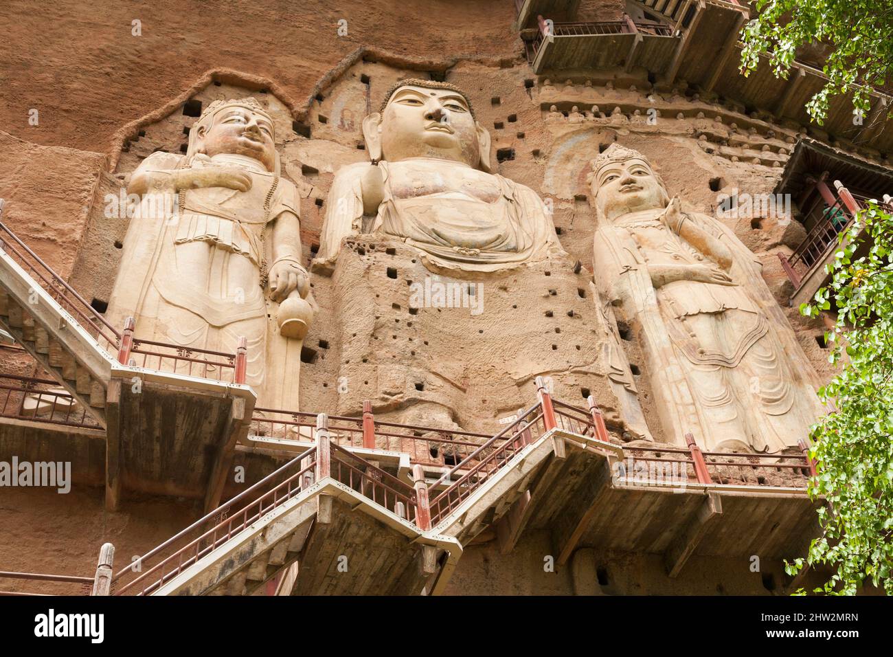 Représentations de Bouddha figures représentations et images bouddhistes (qui semble être restauré très récemment à l'aide de nouveaux matériaux) sur la face rocheuse des grottes de Maijishan, autrefois romanisée comme Maichishan, Qui sont une série de 194 grottes coupées sur le flanc de la colline de Majishan à Tianshui, province de Gansu, Chine. Des escaliers et des passerelles sont fixés à la face de roche pure pour permettre aux visiteurs d'entrer en contact étroit avec les figures d'argile et les anciennes sculptures en pierre sur le site. (67/125) Banque D'Images