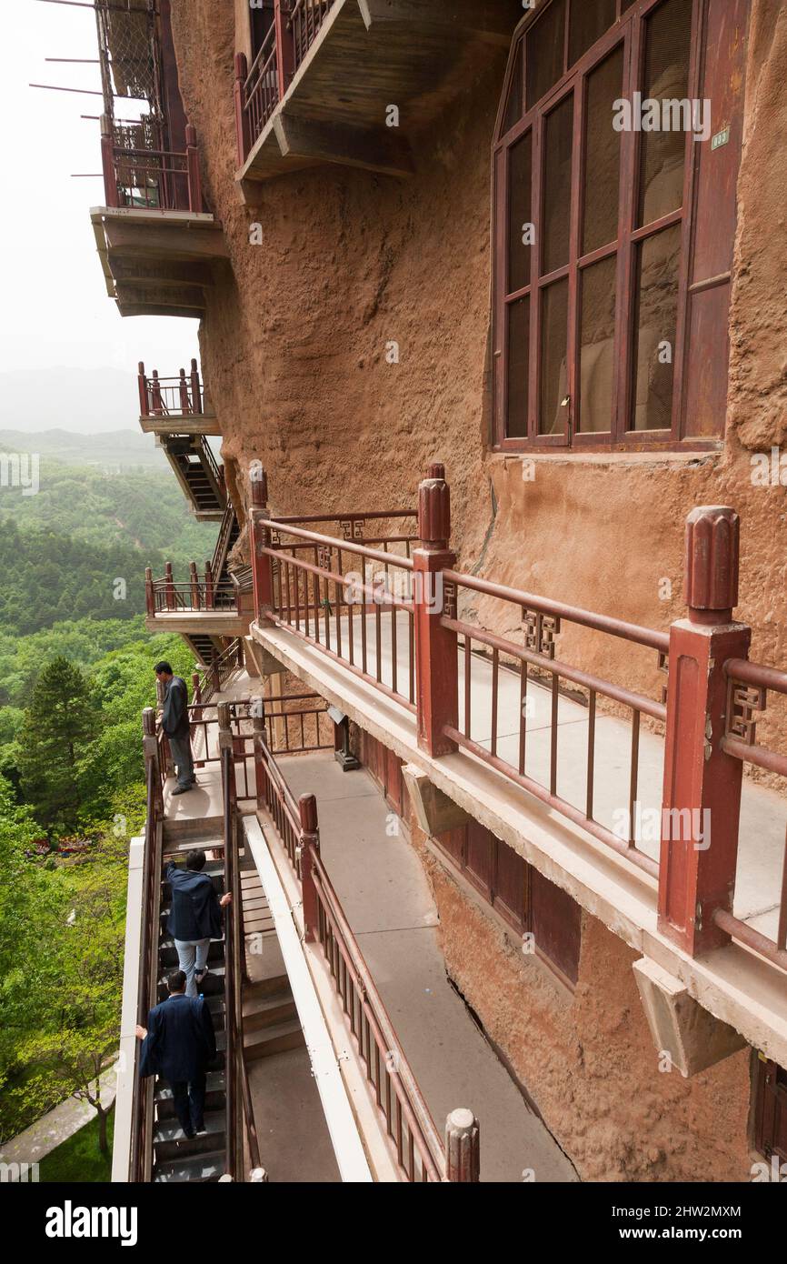 Les marches et les passerelles attachées à la roche permettent aux visiteurs de voir les anciennes statues en argile de Bouddha et de la statue de divinités bouddhistes attachées et sculptées dans la surface de pierre de la face de roche.les grottes de Maijishan, autrefois romanisées comme Maichishan, Sont une série de 194 grottes coupées sur le flanc de la colline de Majishan à Tianshui, province de Gansu, Chine. (67/125) Banque D'Images