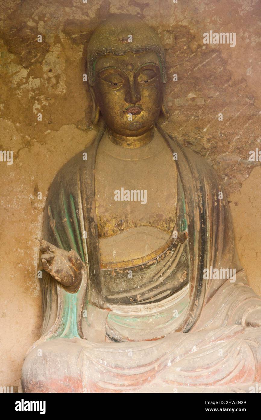 Statue de Bouddha dans la grotte 027. Les marches et les passerelles attachées à la roche permettent aux visiteurs de voir les anciennes statues en argile de Bouddha et de la statue de divinités bouddhistes attachées et sculptées dans la surface de pierre de la face de roche.les grottes de Maijishan, autrefois romanisées comme Maichishan, Sont une série de 194 grottes coupées sur le flanc de la colline de Majishan à Tianshui, province de Gansu, Chine. (67/125) Banque D'Images