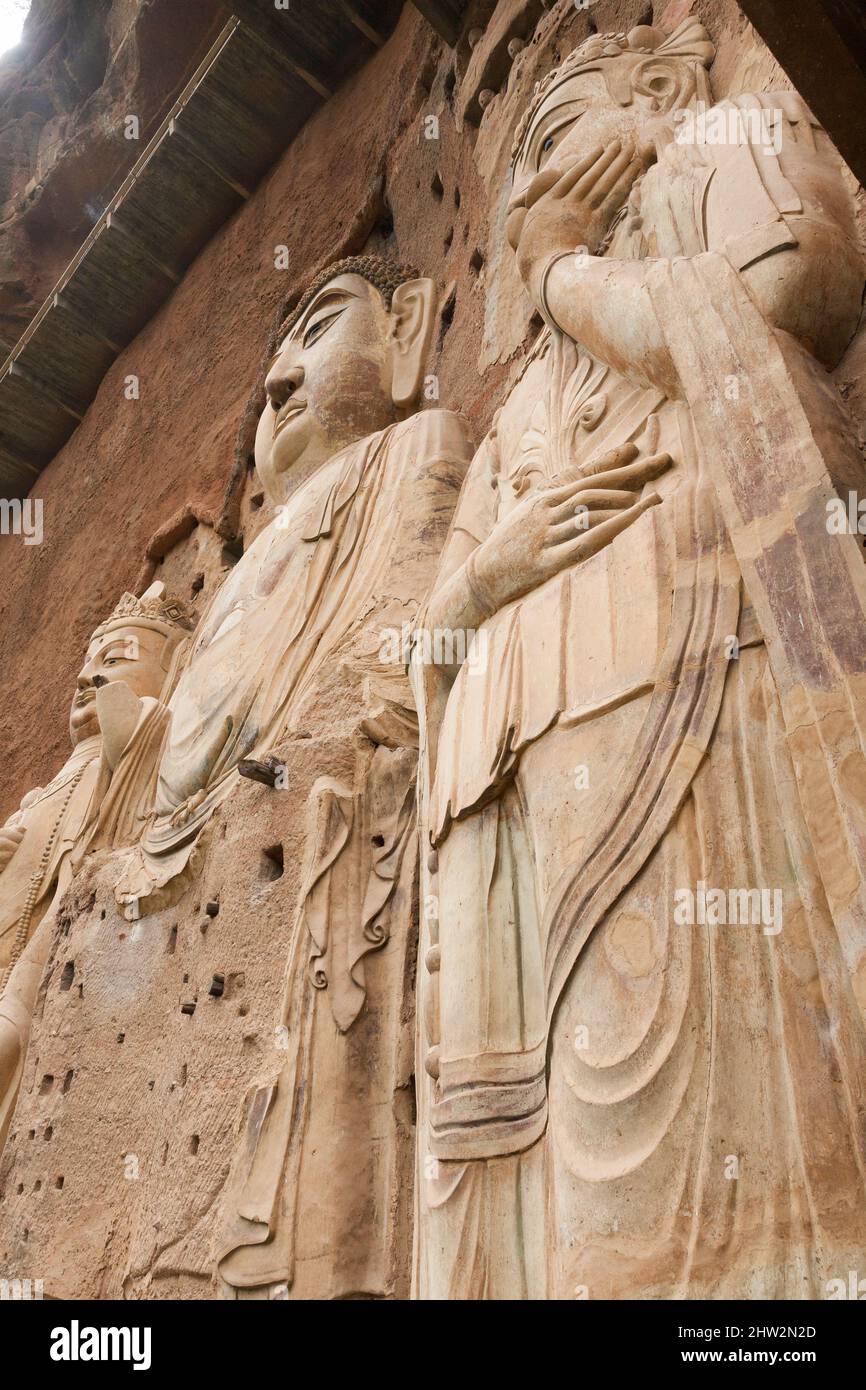 Représentations de Bouddha figures représentations et images bouddhistes (qui semble être restauré très récemment à l'aide de béton) sur la face rocheuse des Grottes de Maijishan, autrefois romanisées comme Maichishan, qui sont une série de 194 grottes coupées sur le côté de la colline de Majishan à Tianshui, province de Gansu, Chine. Des escaliers et des passerelles sont fixés à la face de roche pure pour permettre aux visiteurs d'entrer en contact étroit avec les figures d'argile et les anciennes sculptures en pierre sur le site. (67/125) Banque D'Images