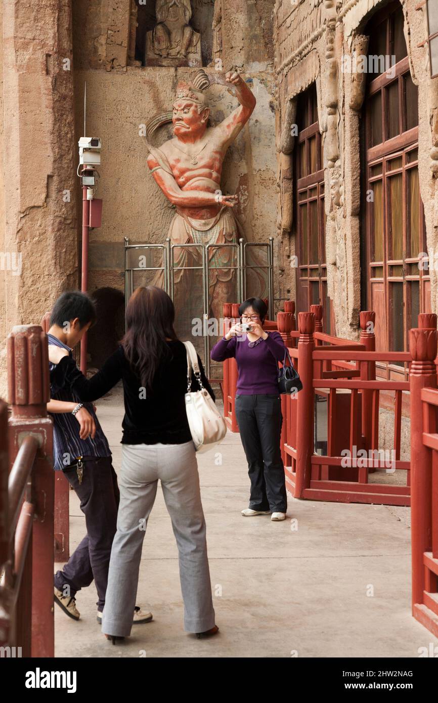 Grotte 004 qui a été construite pendant la période nord de Zhou dans les années 557 à 581. Les marches et les passerelles attachées à la roche permettent aux visiteurs de voir les anciennes statues en argile de Bouddha et de la statue de divinités bouddhistes attachées et sculptées dans la surface de pierre de la face de roche.les grottes de Maijishan, autrefois romanisées comme Maichishan, Sont une série de 194 grottes coupées sur le flanc de la colline de Majishan à Tianshui, province de Gansu, Chine. (67/125) Banque D'Images