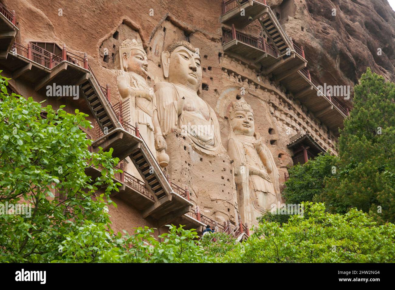 Représentations de Bouddha figures les représentations et les images bouddhistes (qui semblent être récemment restaurées à l'aide de béton) sur la face rocheuse des Grottes de Maijishan, autrefois romanisées comme Maichishan, sont une série de 194 grottes coupées sur le flanc de la colline de Majishan à Tianshui, province de Gansu, Chine. Des escaliers et des passerelles sont fixés à la face de roche pure pour permettre aux visiteurs d'entrer en contact étroit avec les figures et les anciennes sculptures en pierre du site. (67 /125) Banque D'Images